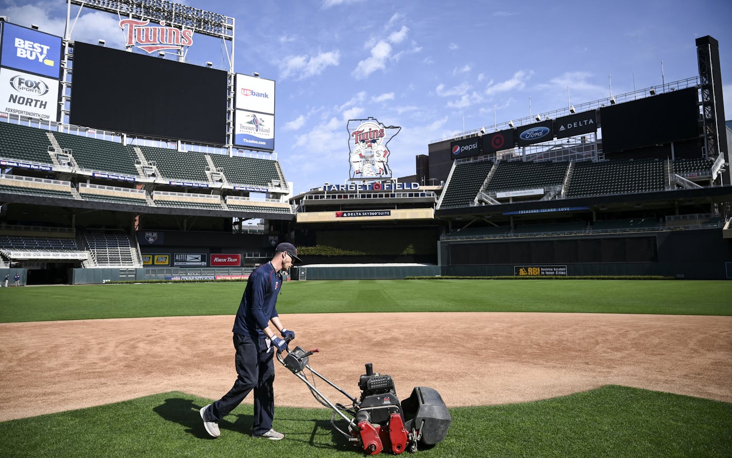 Grounds crew member Reid Olson, of Minnetonka, used a greens mower to cut the grass near second base Friday afternoon. ] Aaron Lavinsky &#x2022; aaron.lavinsky@startribune.com The grounds crew cut the grass at Target Field on Minneapolis, Minn. on Friday, March 27, 2020. ORG XMIT: MIN2003271613150277