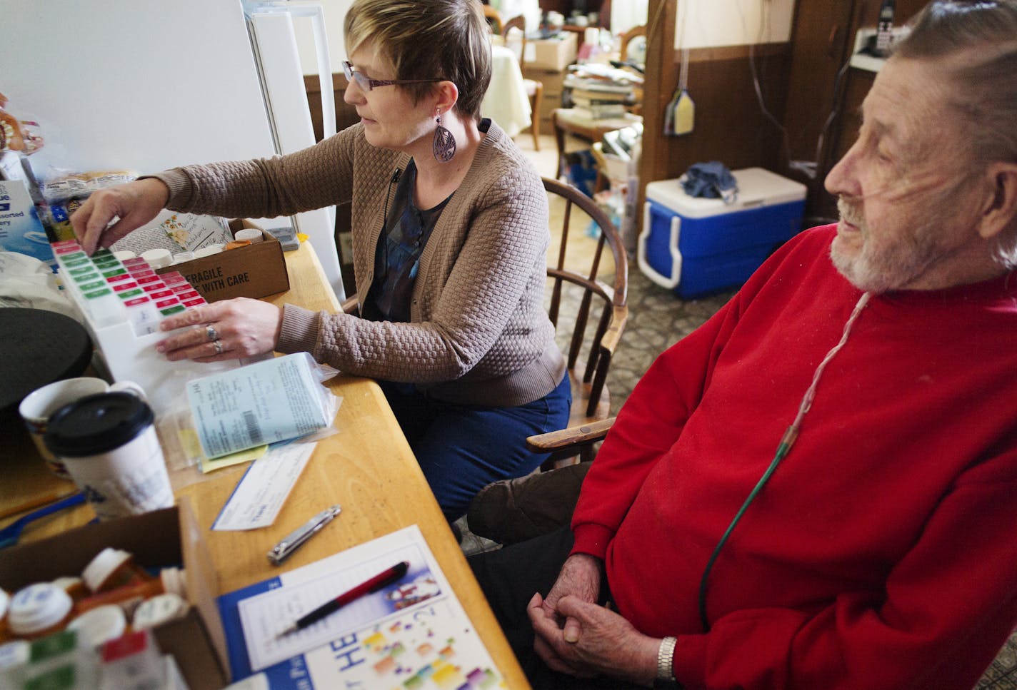 In Stewartville at the home of parents Barbara and Ronald Hatcher, Toni Mangskau helps her dad figure out his medicine for the month so he does not make a mistake due to confusion.] Richard Tsong-Taatarii/ rtsong- taatarii@startribune.com