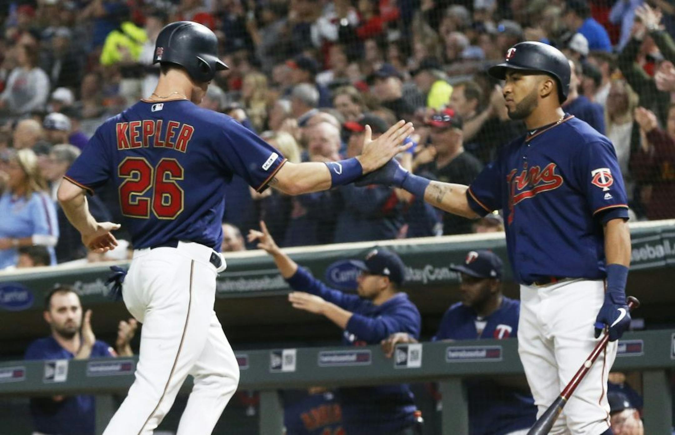 Minnesota Twins' Eddie Rosario, right, greets Max Kepler after he scored on a C.J. Cron double off Milwaukee Brewers pitcher Junior Guerra in the seventh inning.