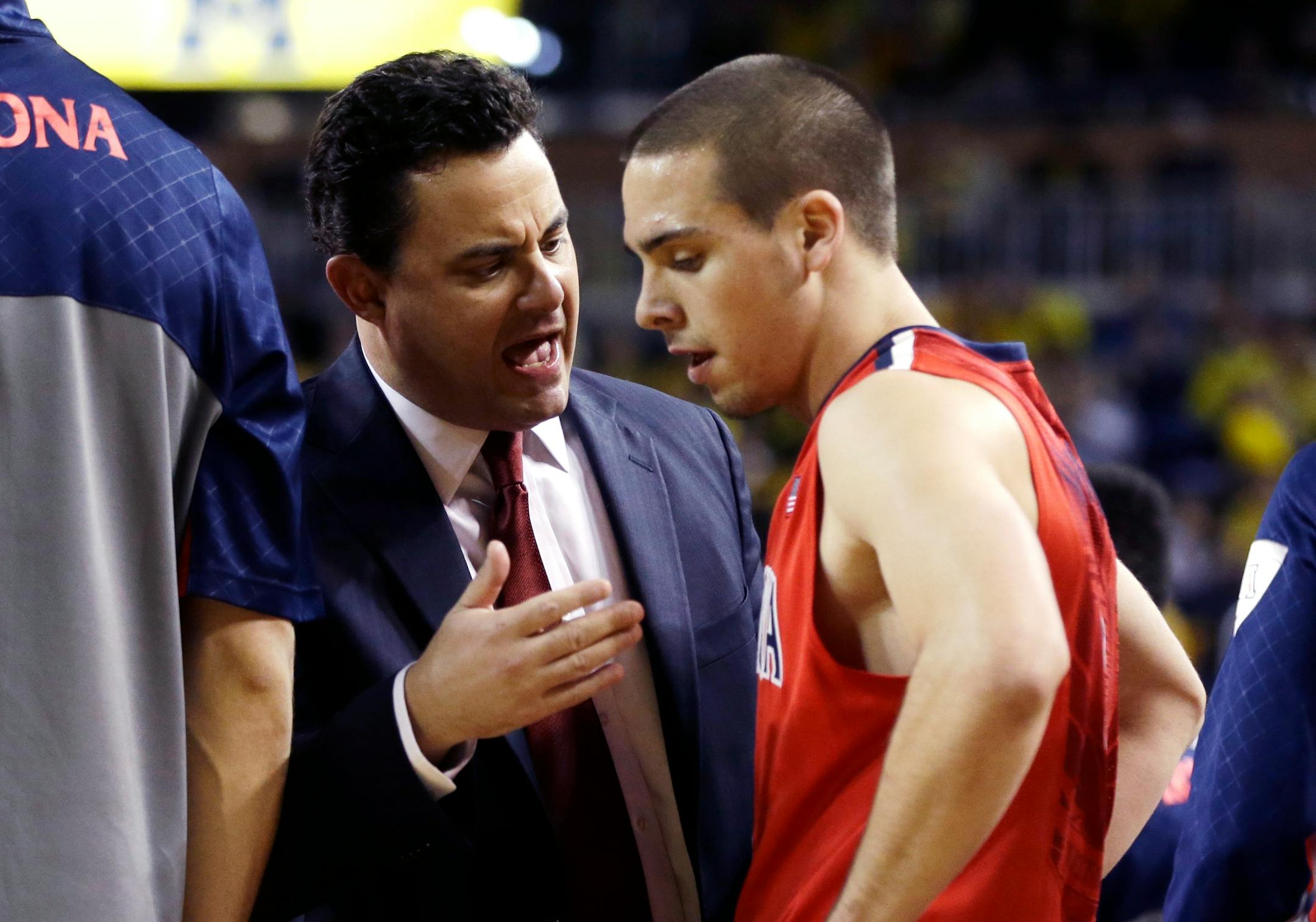 Arizona head coach Sean Miller talks with guard T.J. McConnell (4) during a timeout in the first half of an NCAA college basketball game against Michigan in Ann Arbor, Mich., Saturday, Dec. 14, 2013. (AP Photo/Carlos Osorio)