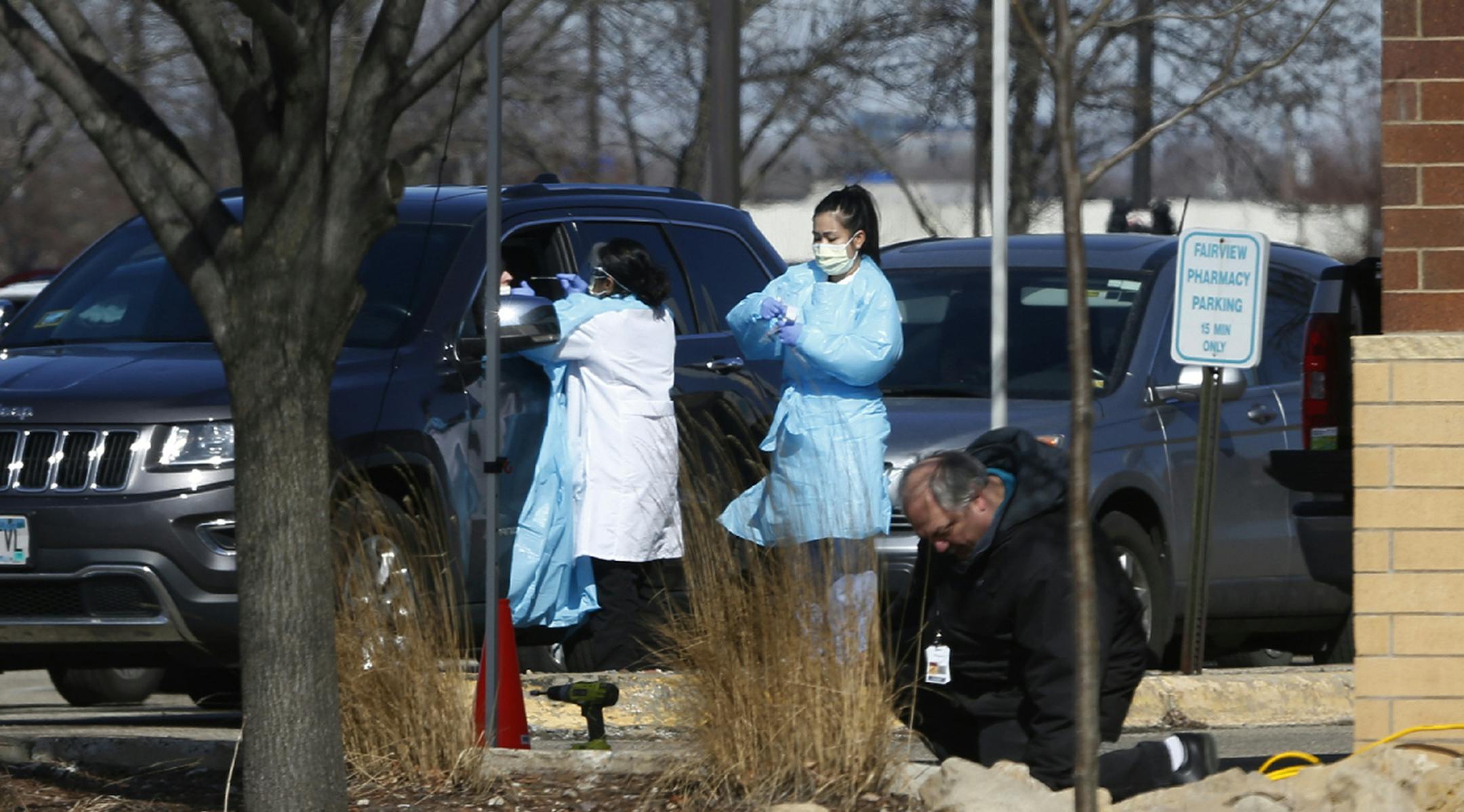 Medical staff wearing safety garments assist a driver at a new coronavirus drive-up test clinic, one of several in the metropolitan Twin Cities area, Friday, March 13, 2020, in Bloomington, Minn. The vast majority of people recover from the new coronavirus. According to the World Health Organization, most people recover in about two to six weeks, depending on the severity of the illness. (AP Photo/Jim Mone)