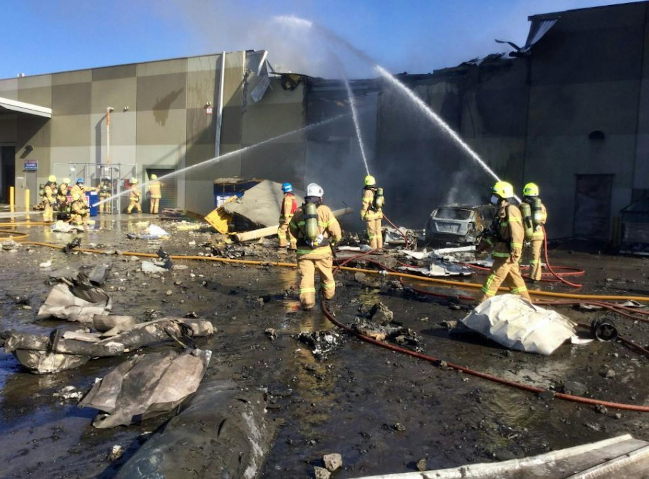 Melbourne Fire Brigade firefighters douse a fire at a shopping mall after a small plane carrying four U.S. tourists and a pilot crashed.