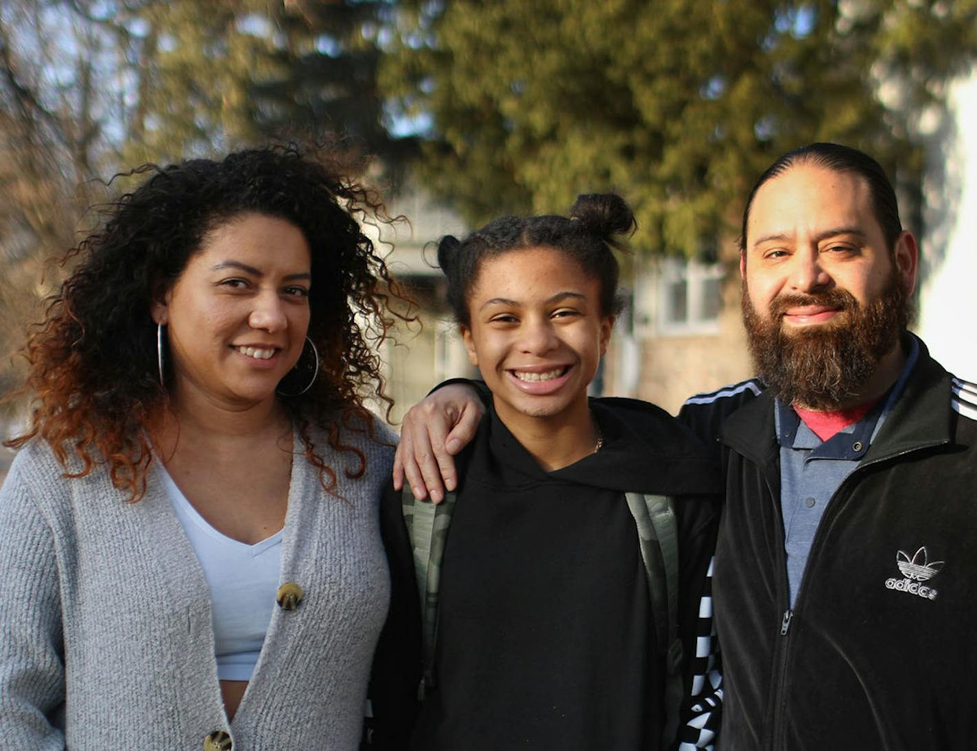 Stephanie Gasca, left, and fianc&#xe9; Jimmy Patino, right, are north Minneapolis parents with a blended family who have kids enrolled in Anwatin Middle School and North High School. They are skeptical about the district redesign and think officials aren't focusing on many issues that underlie the achievement gap. They posed with Gasca's daughter Kennedy, 11, who attends Anwatin Middle School, after they walked her from the bus stop to their home several blocks away Friday, March 6, 2020, in Min