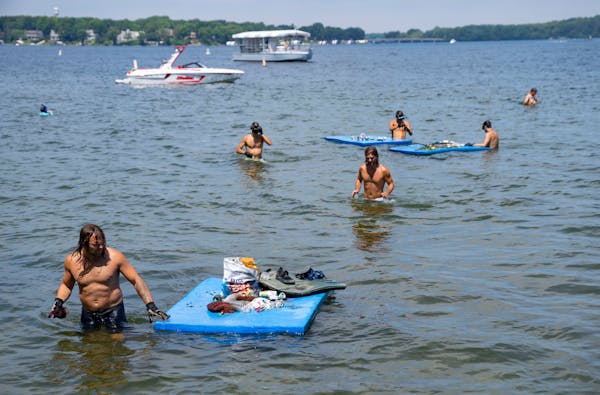 On the day after July 4th, volunteers look for trash left over from holiday festivities near Big Island on Lake Minnetonka.