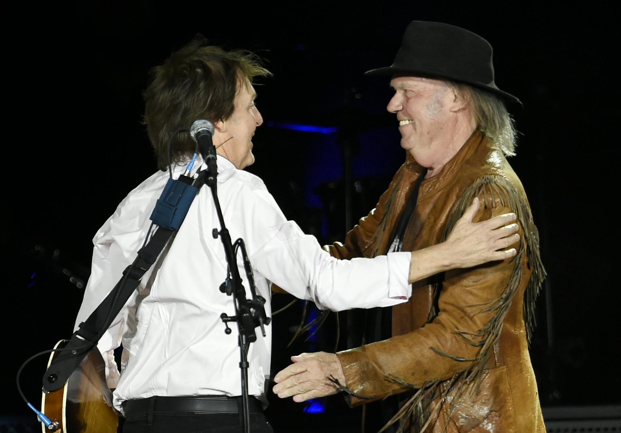 Paul McCartney, left, greets Neil Young onstage during McCartney's performance on day 2 of the 2016 Desert Trip music festival at Empire Polo Field on Saturday, Oct. 8, 2016, in Indio, Calif.