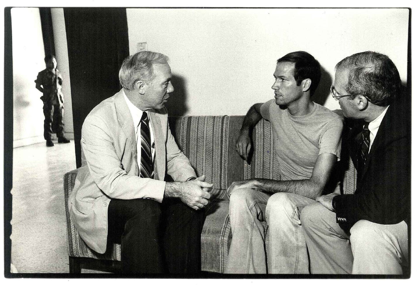 Mn. Representative James Oberstar, left, talks with freelance reporter T.J. Western of the Twin Cities, in police custody i El Salvador. John McAward, at right, listens. Western was released from jail on Wednesday through Oberstar's and McAward's intervention. Photo by Lou Jones/Unitarian Universalist Service Committee. Date taken 4/31/83 ORG XMIT: MIN2014050316005329