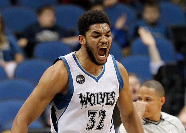 Minnesota Timberwolves center Karl-Anthony Towns (32) reacts after making a shot against the Phoenix Suns during the first half of an NBA basketball g