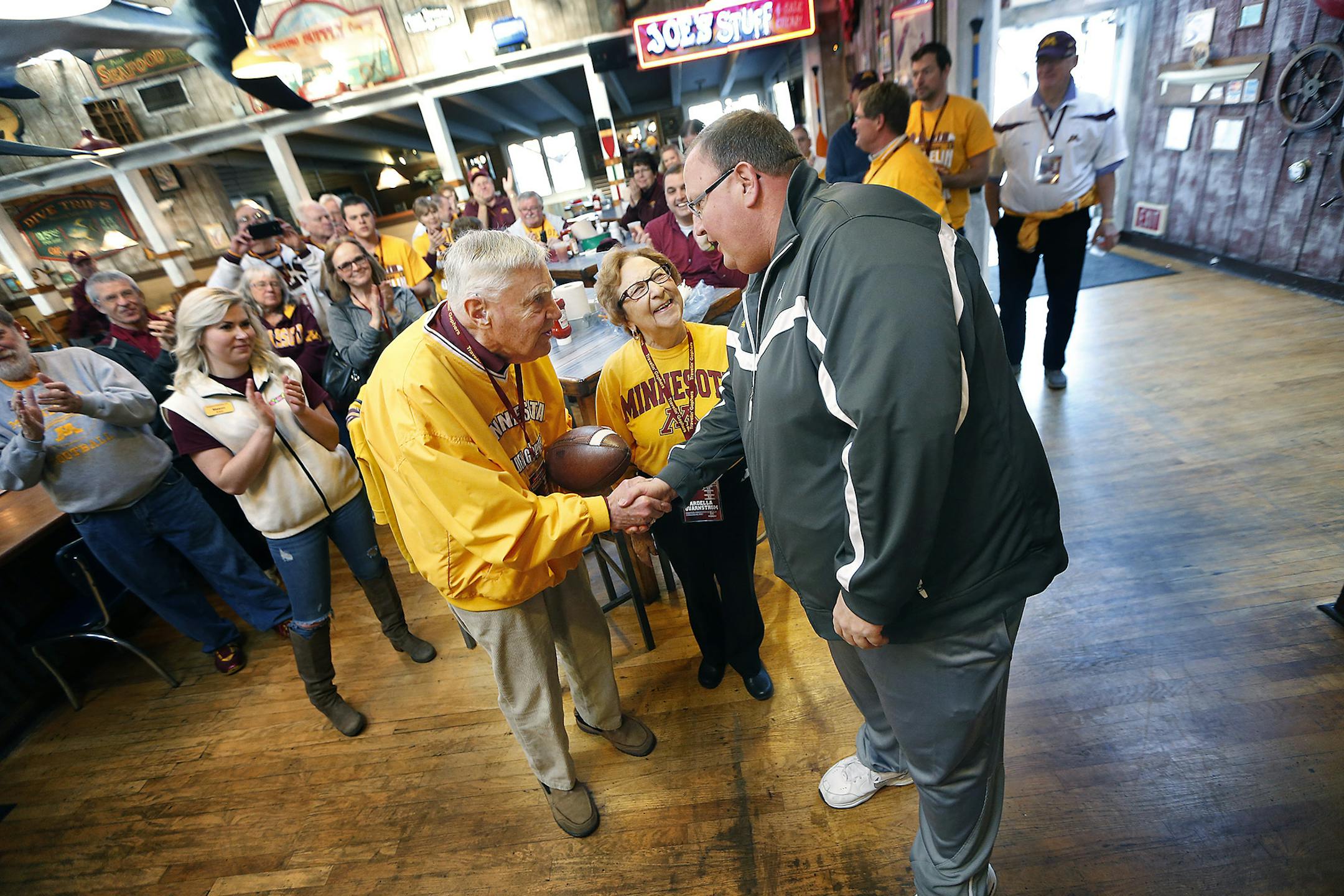 Gophers football coach Tracy Claeys made a surprise appearance as he presented Warren and Ardella Quarnstrom with a football during a breakfast Tuesday in San Diego.