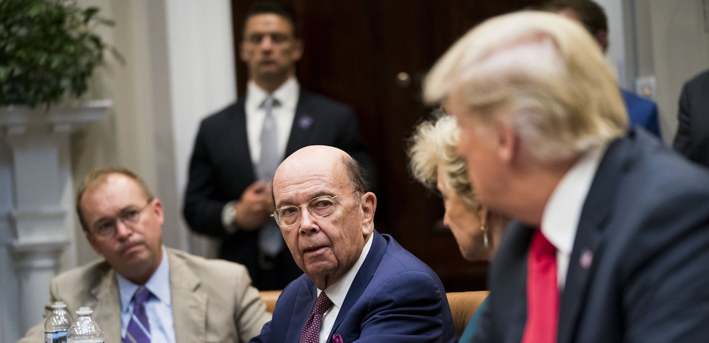 FILE-- Commerce Secretary Wilbur Ross speaks to President Donald Trump during the first meeting of the President's National Council for the American Worker at the White House in Washington, Sept. 17, 2018. A federal judge blocked the Commerce Department on Jan. 15, 2019, from adding a question on American citizenship to the 2020 census, handing a legal victory to critics who accused the Trump administration of trying to turn the census into a tool to advance Republican political fortunes. (Doug