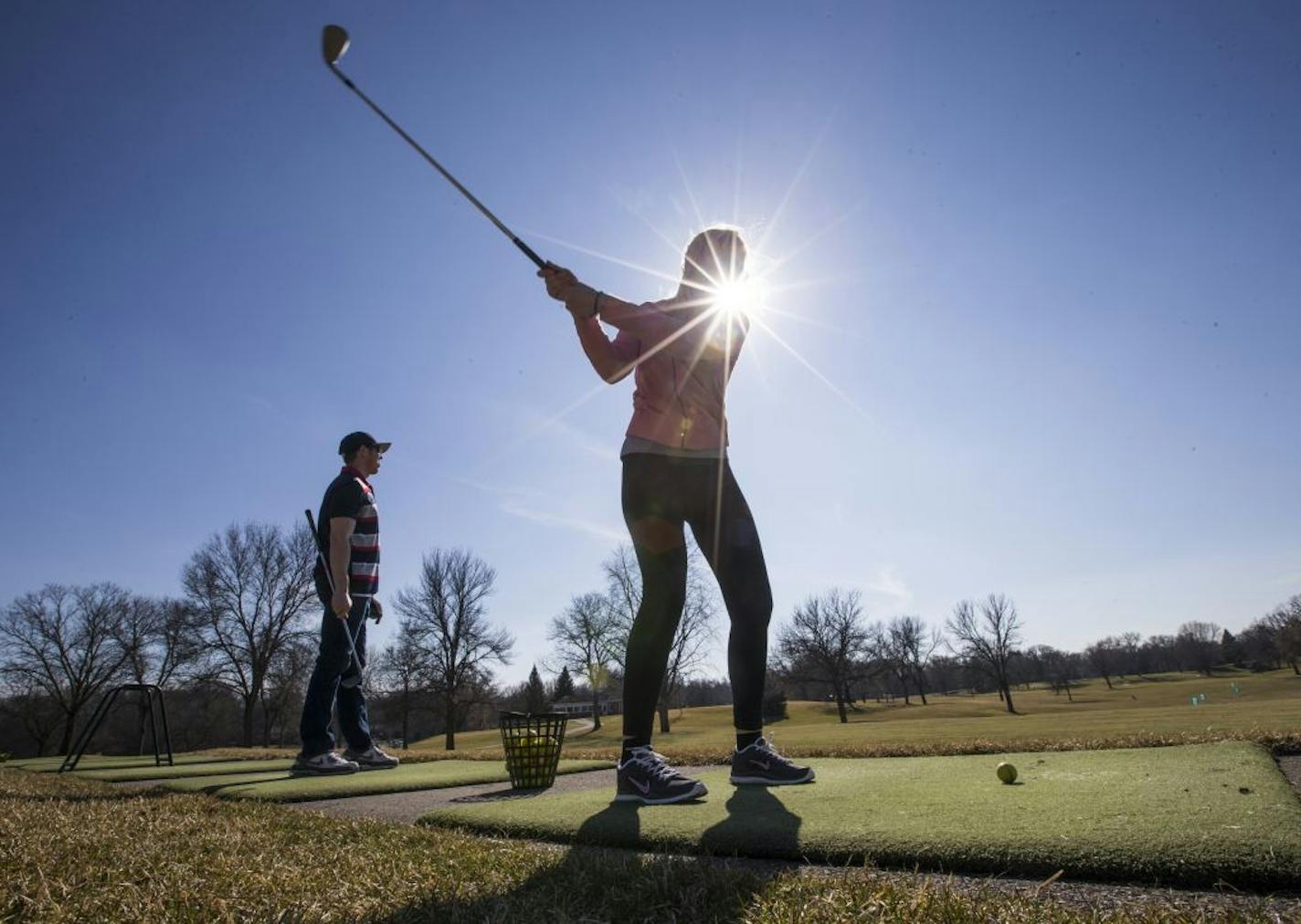 Stacy Coldwell and Chris Falteisek (left) took the afternoon off of work to go hit balls on the driving range at Hyland Greens Golf and Learning Center during unseasonably warm temperatures on Friday, March 11, 2016, in Bloomington, Minn.