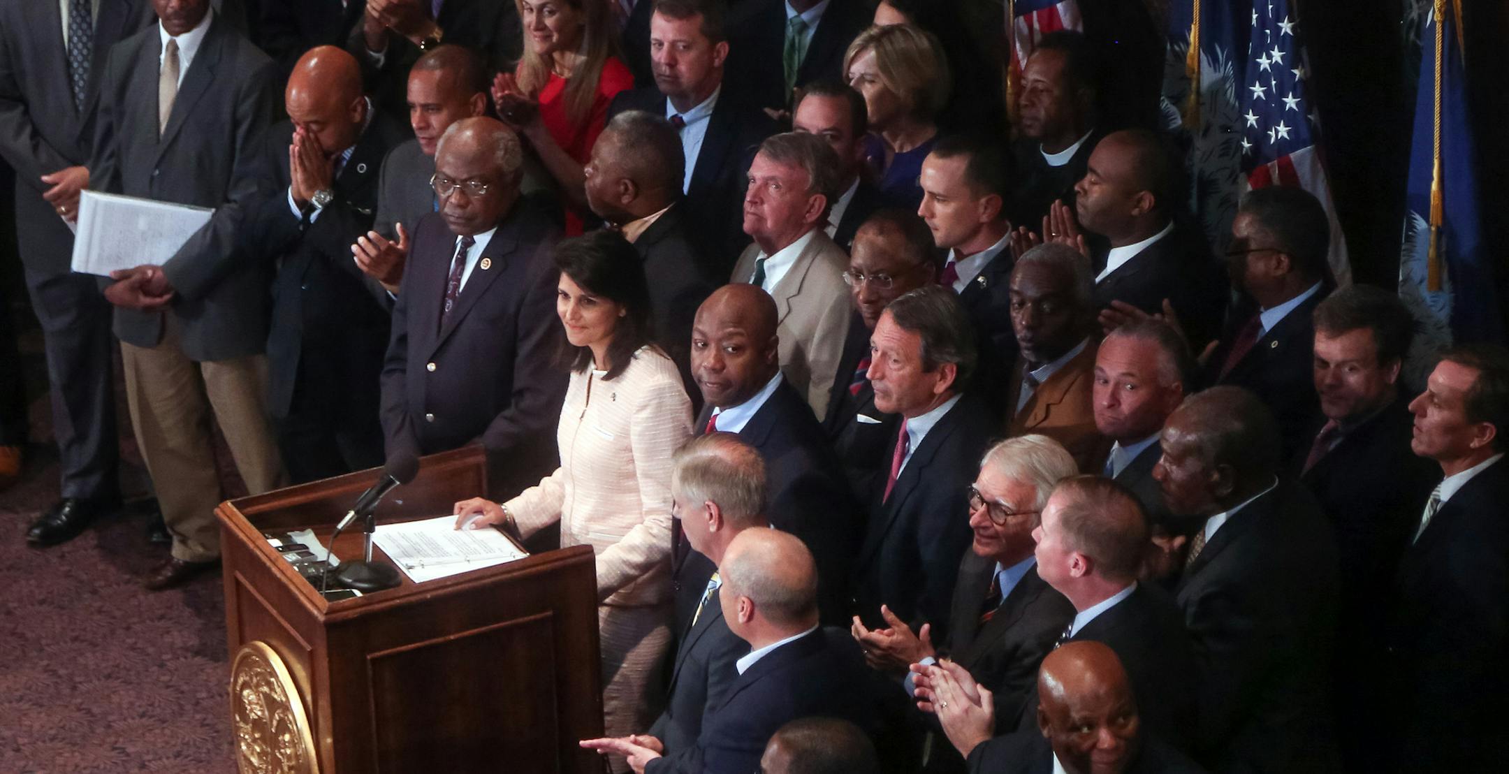 South Carolina Gov. Nikki Haley, middle, is applauded during a news conference in the South Carolina State House, Monday, June 22, 2015, in Columbia, S.C. Haley said that the Confederate flag should come down from the grounds of the state capitol, reversing her position on the divisive symbol amid growing calls for it to be removed. (Tim Dominick/The State via AP)
