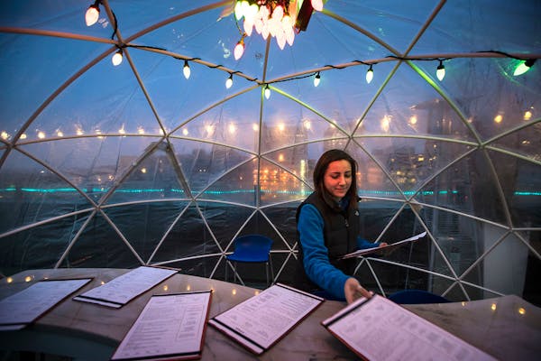 Server Claire Miller set up a table in an igloo on the rooftop at La Vetta on Wednesday, January 10, 2018, in Rochester, Minn.