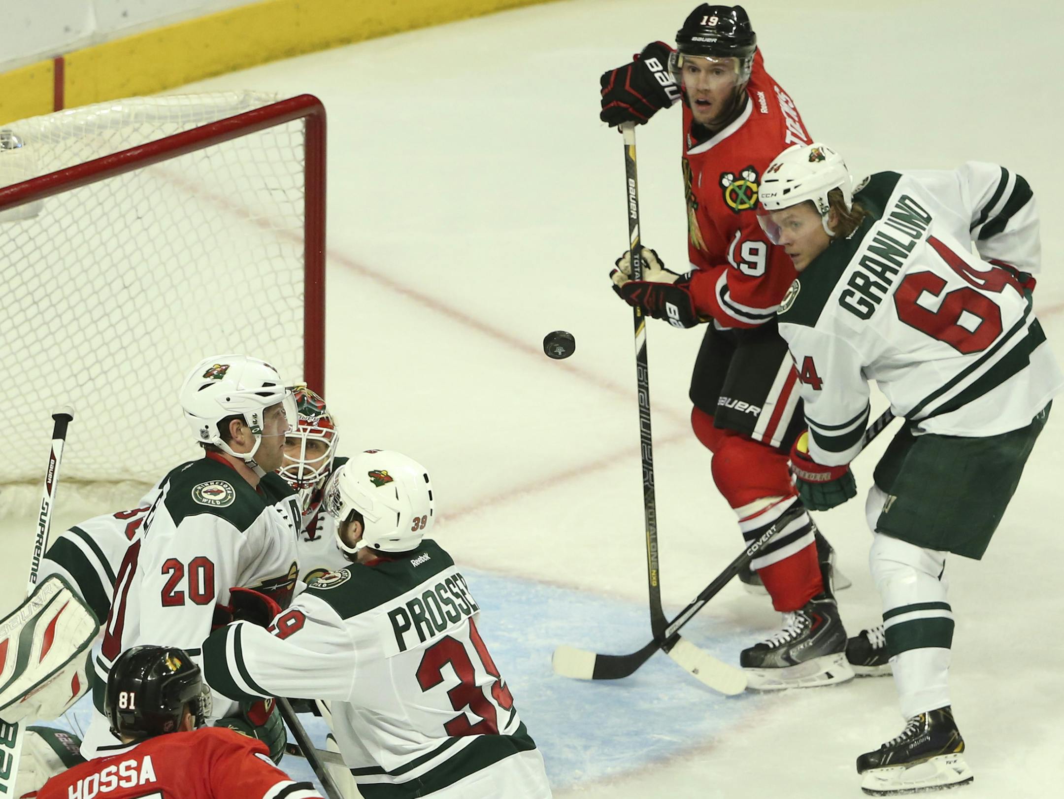 Chicago Blackhawks center Jonathan Toews (19) watched an incoming shot he corraled and then put in the net for the winning goal during the third period of their game Sunday night at United Center in Chicago. He was defended by Minnesota Wild center Mikael Granlund (64). ] JEFF WHEELER ‚Ä¢ jeff.wheeler@startribune.com The Minnesota Wild faced the Chicago Blackhawks in game 5 of their playoff series Sunday night, May 11, 2014 at United Center in Chicago.