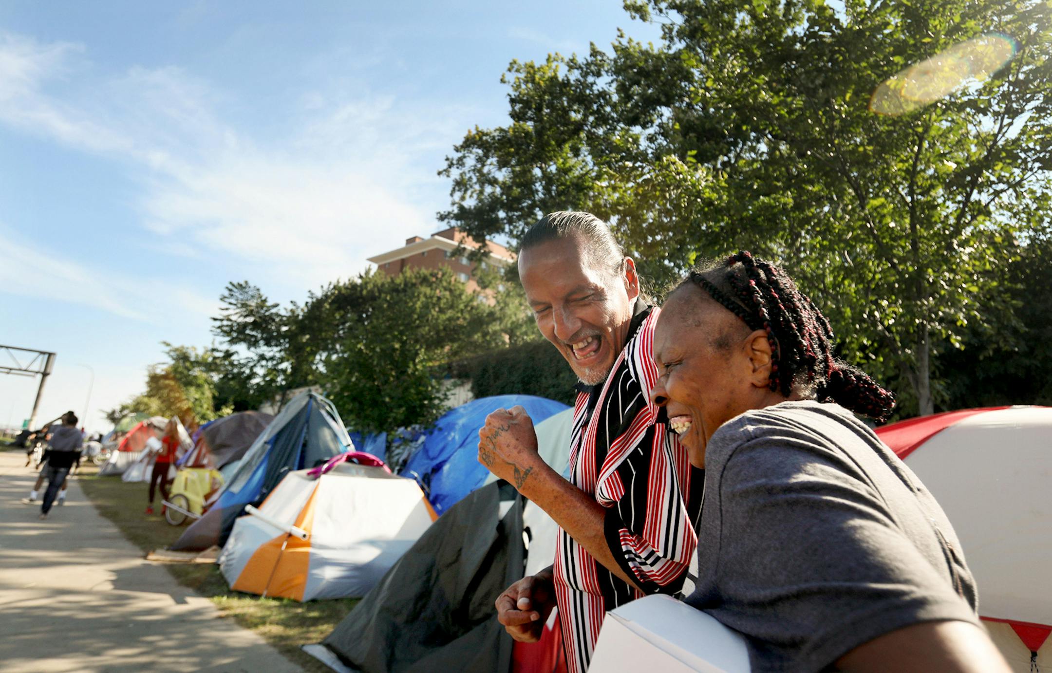 James Cross, the founder of the street outreach group Natives Against Heroin, spent nearly half of his life in prison for drug-related crimes. Here, Cross, who patrols a growing homeless encampment with other members of Natives Against Heroin (NAH), has a light moment with Arlene Thomas, who lives in a nearby high-rise, behind the encampment, and was visiting friends Friday, Sept. 7, 2018, in south Minneapolis, MN. "I knew a lot of these people before they became homeless," said Thomas, who regu