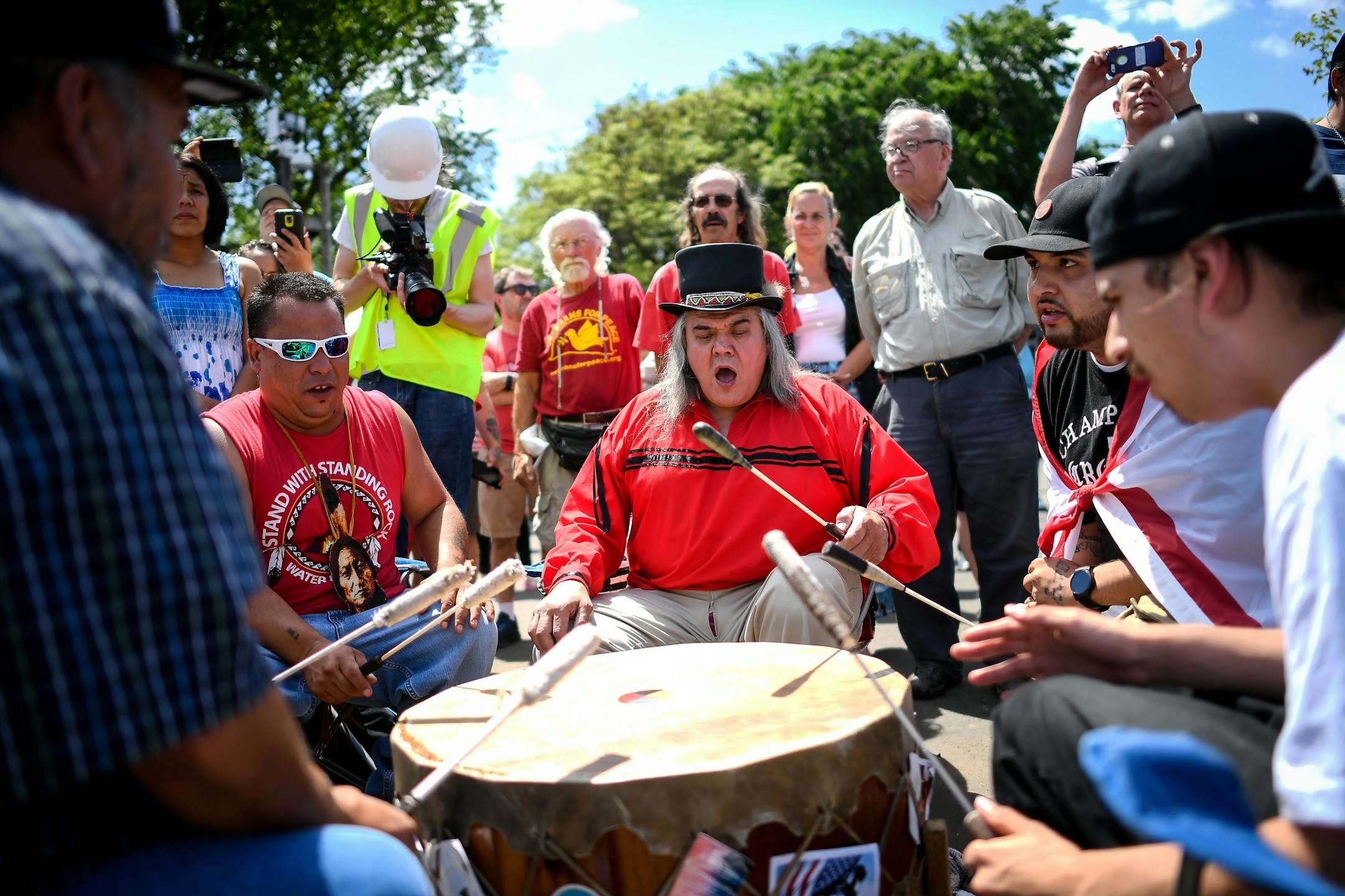 Joseph Bester, the spiritual person for the Mendota Dakota, center, played an honor song with fellow drummers before the start of Friday's ceremony preceding the demolishment of the "Scaffold" sculpture.