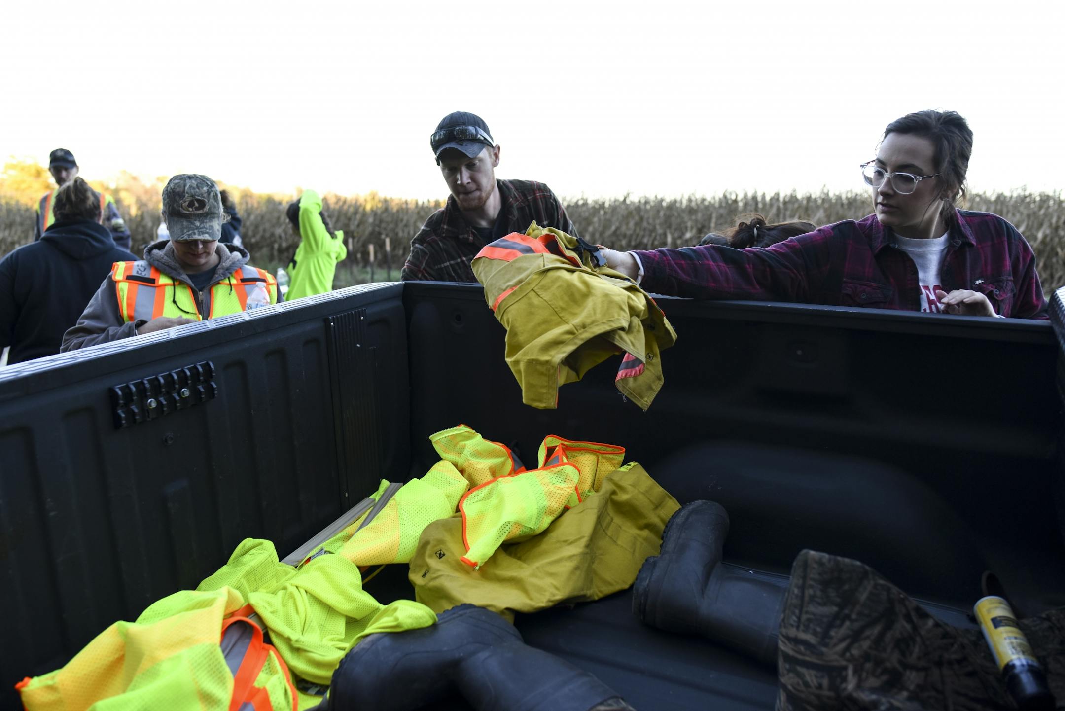 Volunteers tossed their neon vests into the back of a Wisc. DNR conservation warden's truck after their group wrapped up a search for evidence related to the disappearance of 13-year old Jayme Closs and the murder of her parents on Thursday, Oct. 18, 2018.