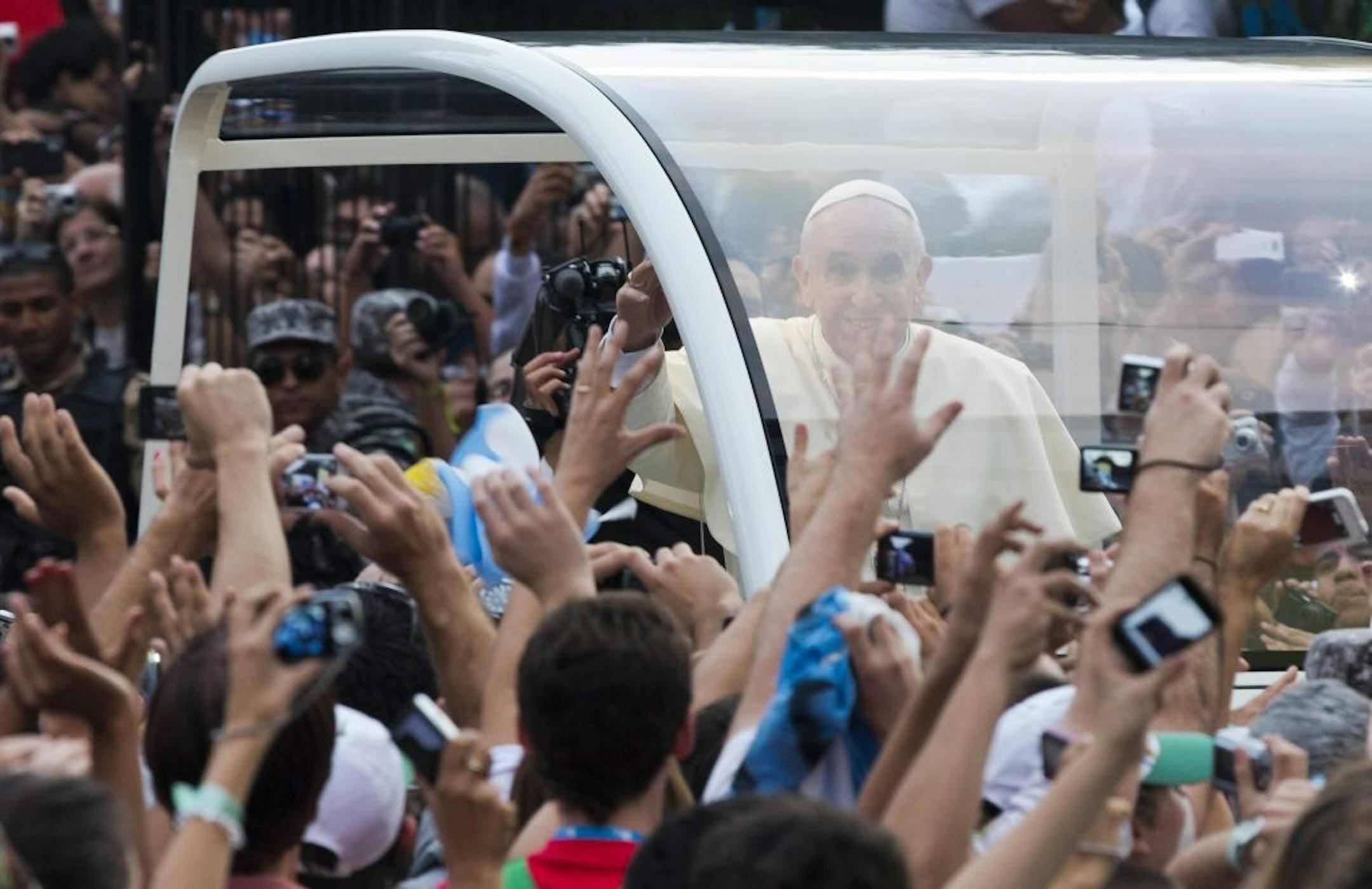 People reach out to Pope Francis as he rides in a popemobile through Rio de Janeiro, Brazil, Monday, July 22, 2013.