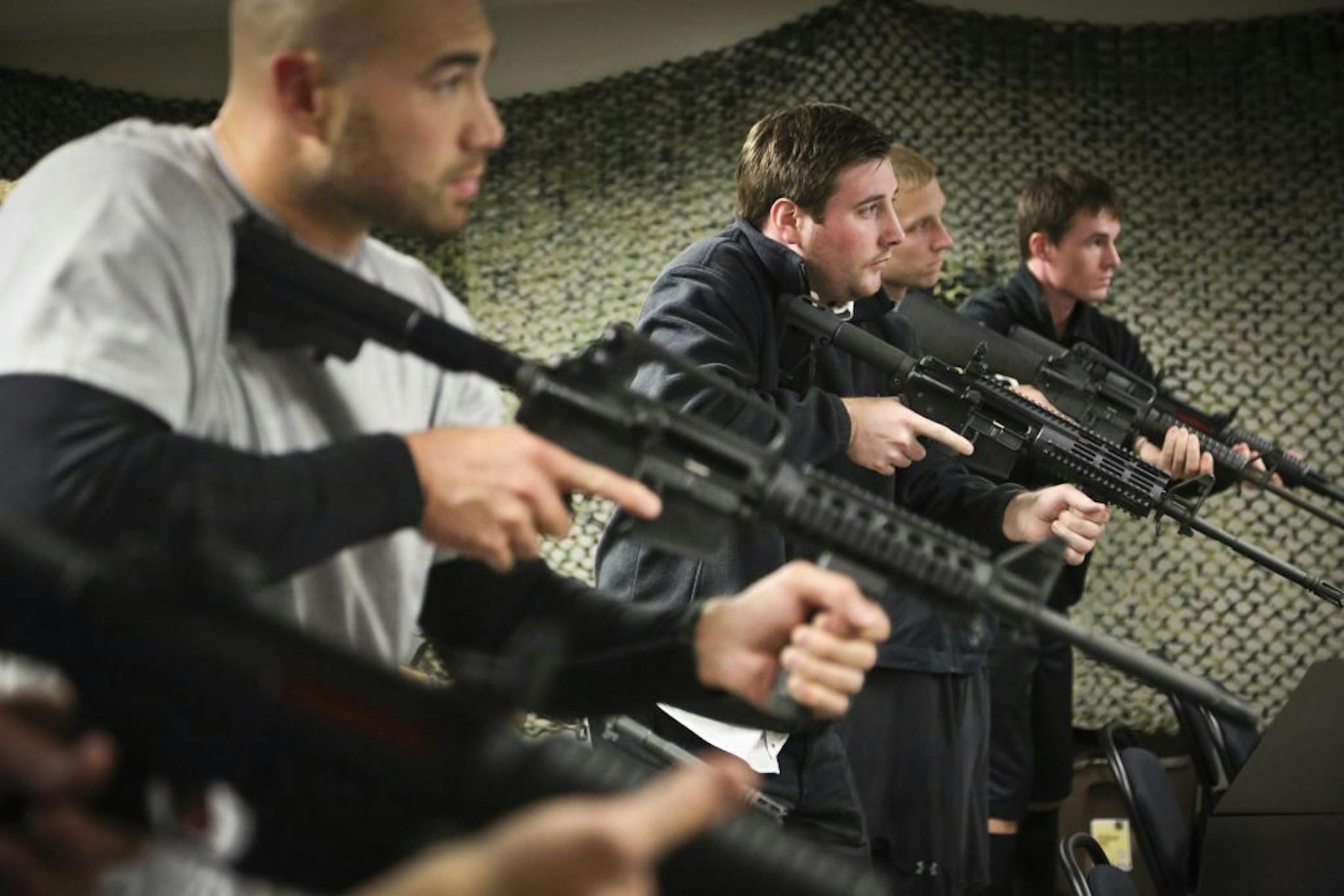 People in a Navy SEAL experience class, including Brenton Hayden, center, learned how to hold an AR-15 assault rifle. The class in New Hope finishes with a simulated killing of Osama bin Laden.