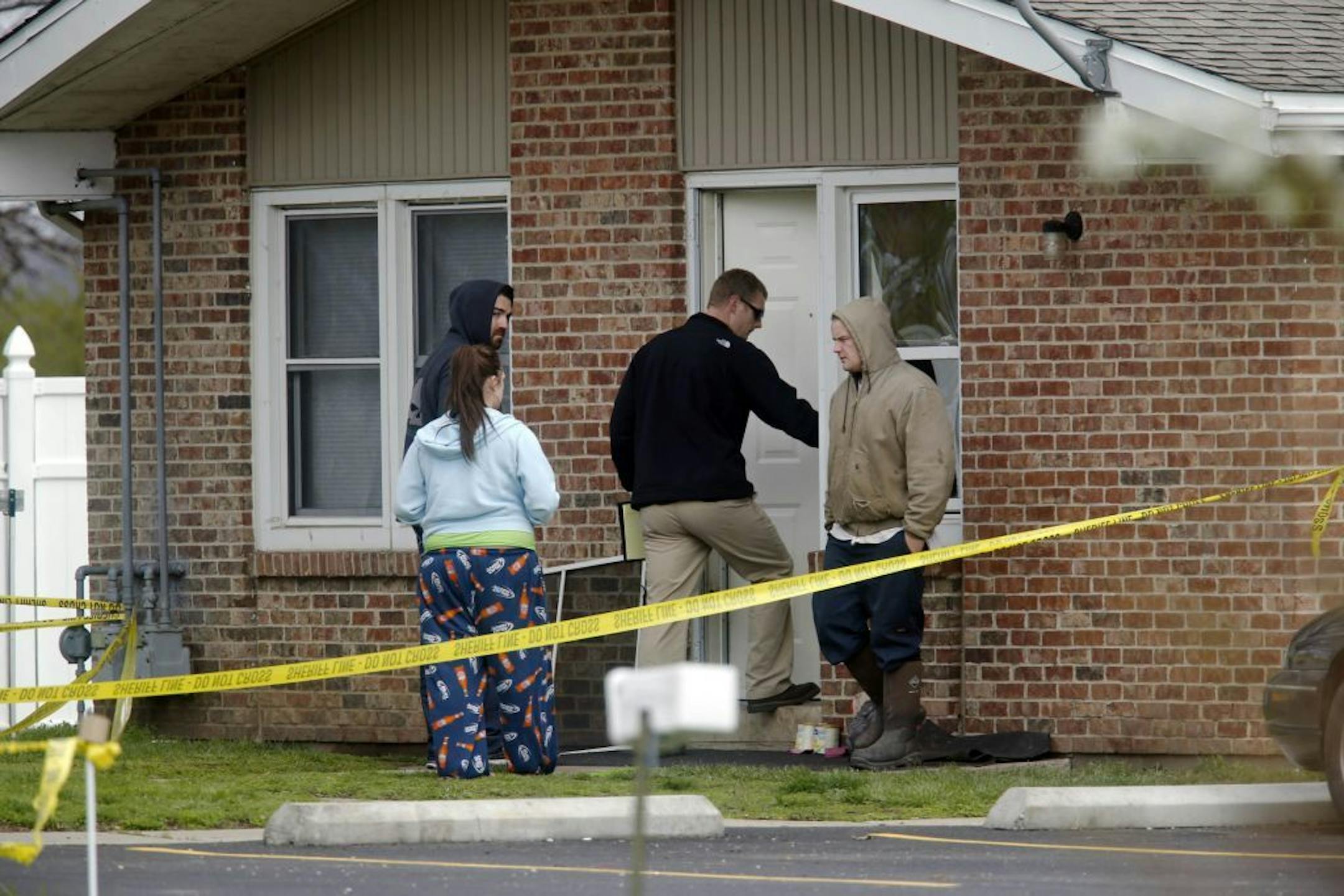 Police officials investigate the scene at a house in Manchester, Ill., where five people were found slain in the tiny southwestern Illinois town early Wednesday, April 24, 2013. Illinois State Police said the suspect died after a car chase and an exchange of gunfire with law enforcement.