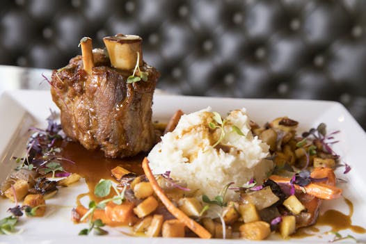The crackling pork shank with roasted root vegetables, Granny Smith apples and cider demi-glace at McKinney Roe.