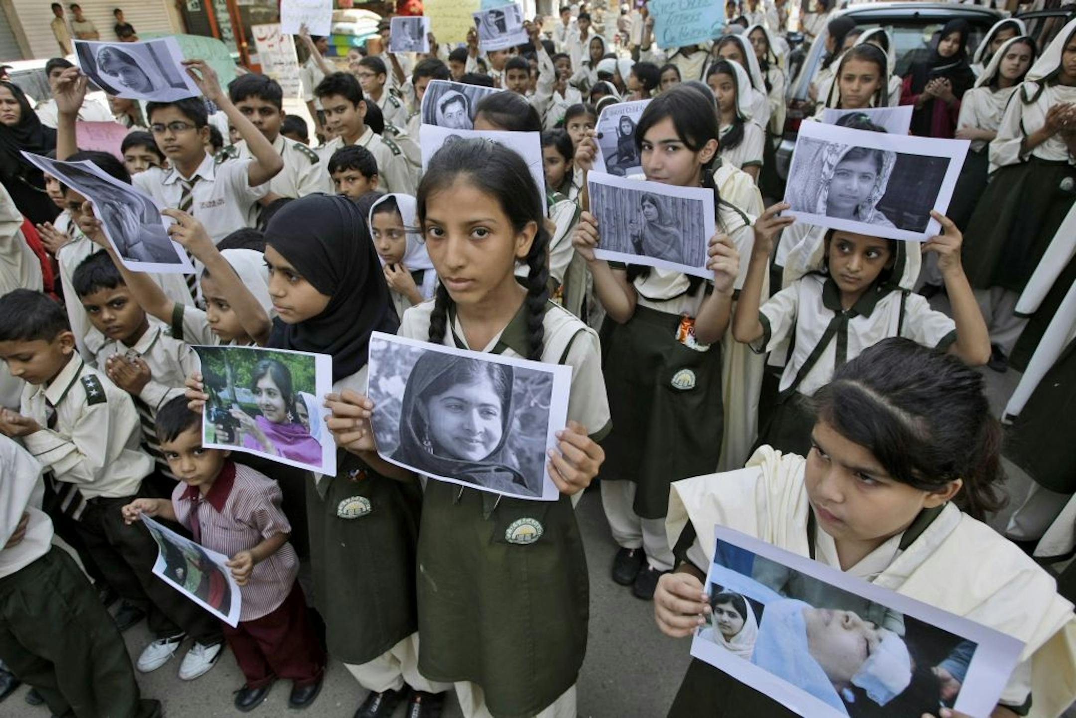 Pakistani students hold pictures of 14-year-old schoolgirl Malala Yousufzai, who was shot last Tuesday by the Taliban for speaking out in support of education for women, during a protest condemning the attack, in Karachi, Pakistan, Saturday, Oct. 13, 2012.