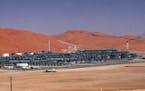 FILE - In this Monday, March 8, 2004 file photo, an industrial plant strips natural gas from freshly pumped crude oil is seen at Saudi Aramco's Shayba