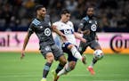 Vancouver Whitecaps' Brian White takes a shot on goal as Minnesota United's Michael Boxall defends