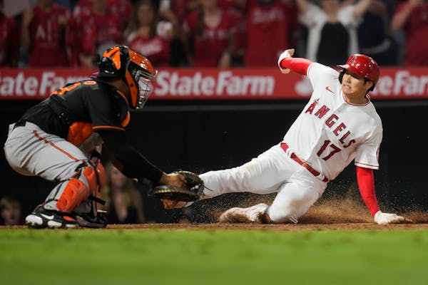 Los Angeles Angels designated hitter Shohei Ohtani (17) slides in to home to score ahead of a tag by Baltimore Orioles catcher Pedro Severino (28) dur