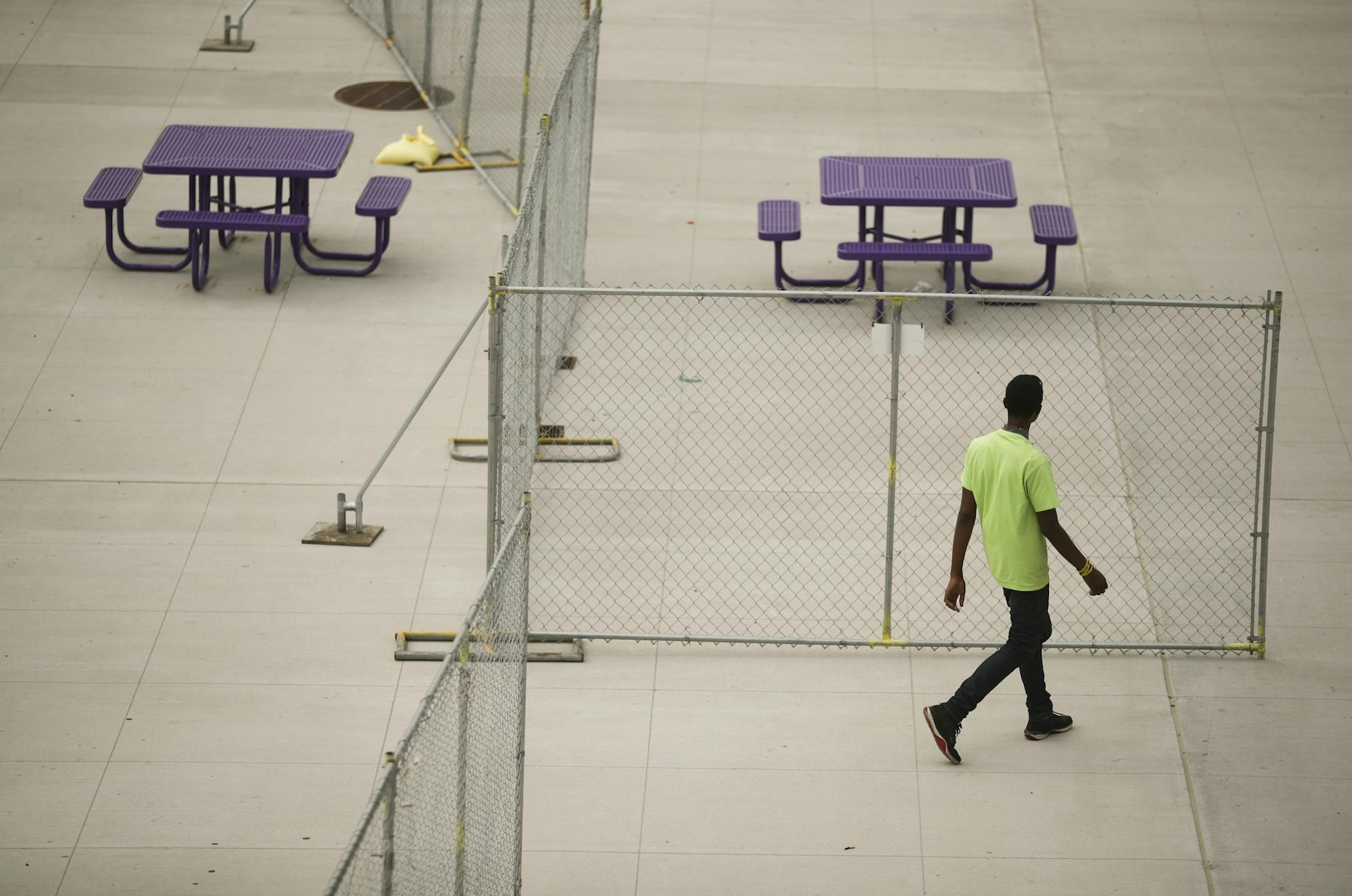 A chain link fence separated picnic tables on the plaza across from U.S. Bank Stadium.