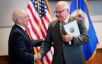 Gov. Tim Walz, right, and Myron Frans, of Management and Budget, had a reason to smile.