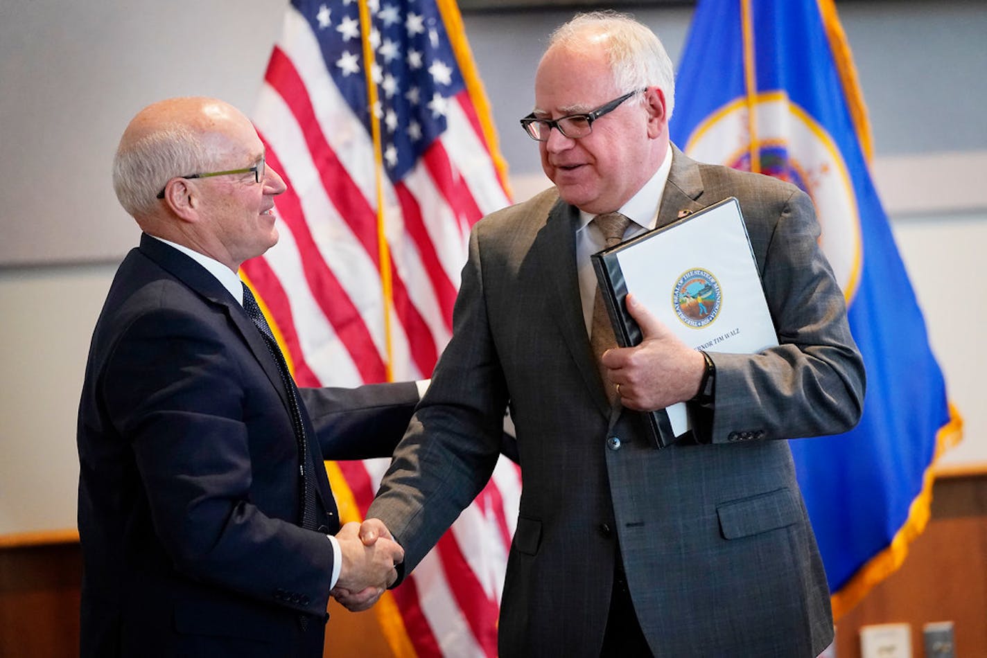 Gov. Tim Walz, right, and Myron Frans, of Management and Budget, had a reason to smile.