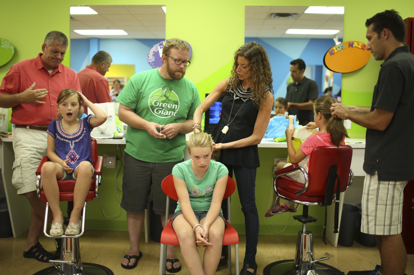 Cozy Friedman showed how to make a ponytail on Eva Patenaude, 10, while her father, Eric, watched at Kids&#x2019; Hair in Edina. Also at the class were Mike and Sophia Korman, left, and Robert and Adeline Wilke.