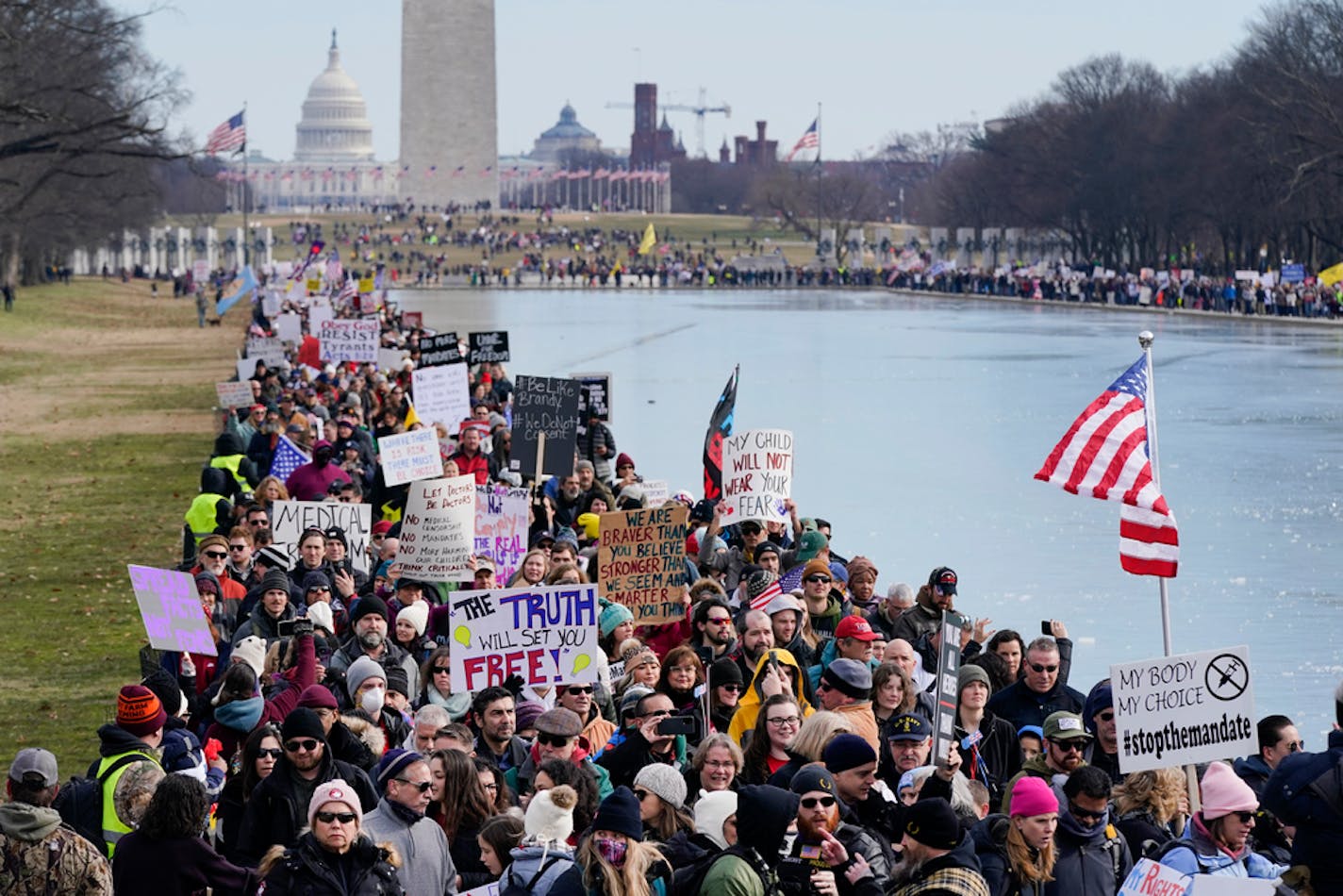 People march alongside the Lincoln Memorial Reflecting Pool before an anti-vaccine rally in Washington on Sunday, Jan. 23, 2022. (AP Photo/Patrick Semansky)