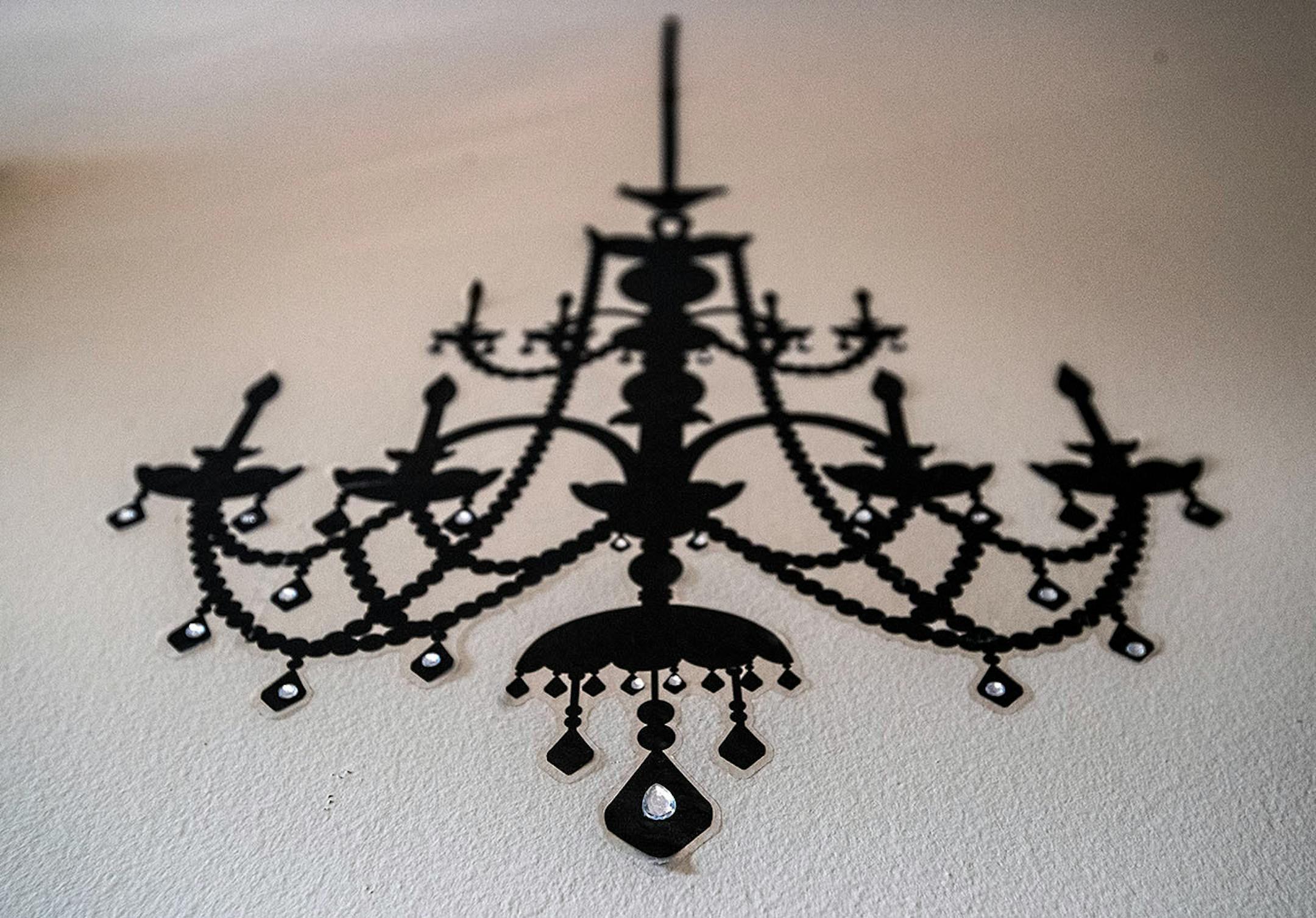 A chandelier decal with rhinestones decorates a wall.