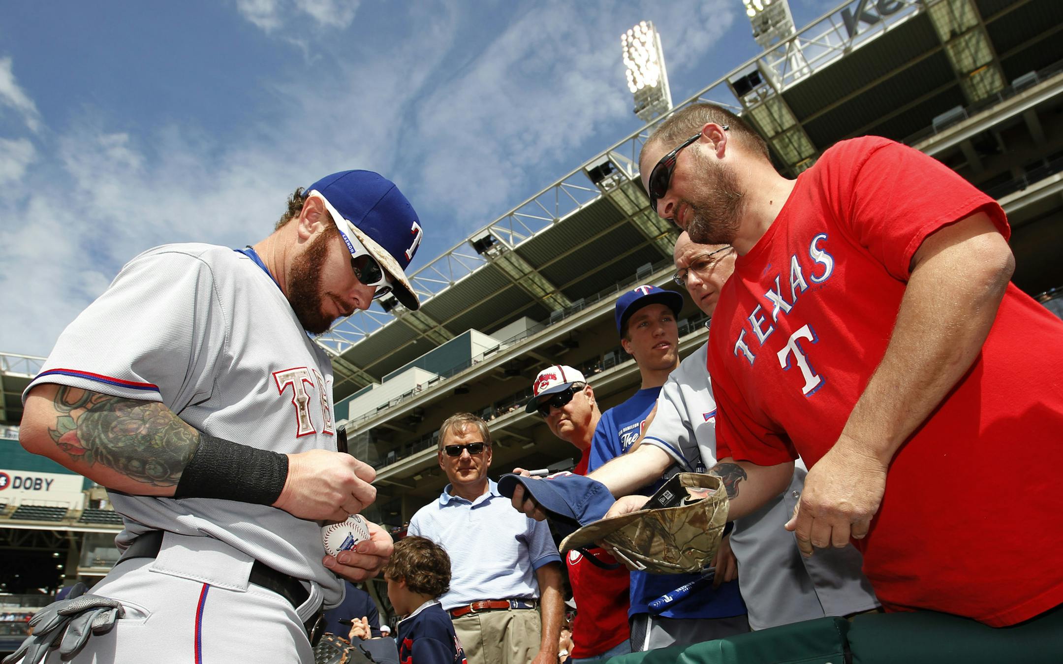 Texas Rangers' Josh Hamilton signs an autograph for a fan prior to the Rangers baseball game against the Cleveland Indians Monday, May 25, 2015, in Cleveland. (AP Photo/Aaron Josefczyk)