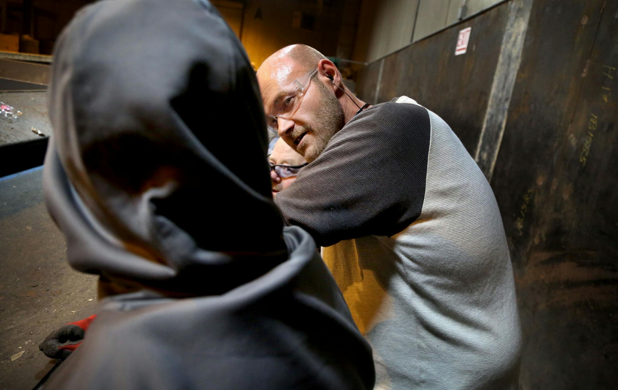 Disabled workers like John Week, 37, have opportunities that they never thought possible. Workers who once toiled for years in dead-end jobs are now making up to $14 an hour at an MDI facility and have opportunities for advancement. Here, Week gets down on the level of a worker while chatting on the recycling sorting line Tuesday, Sept. 27, 2016, in Cohasset, MN.