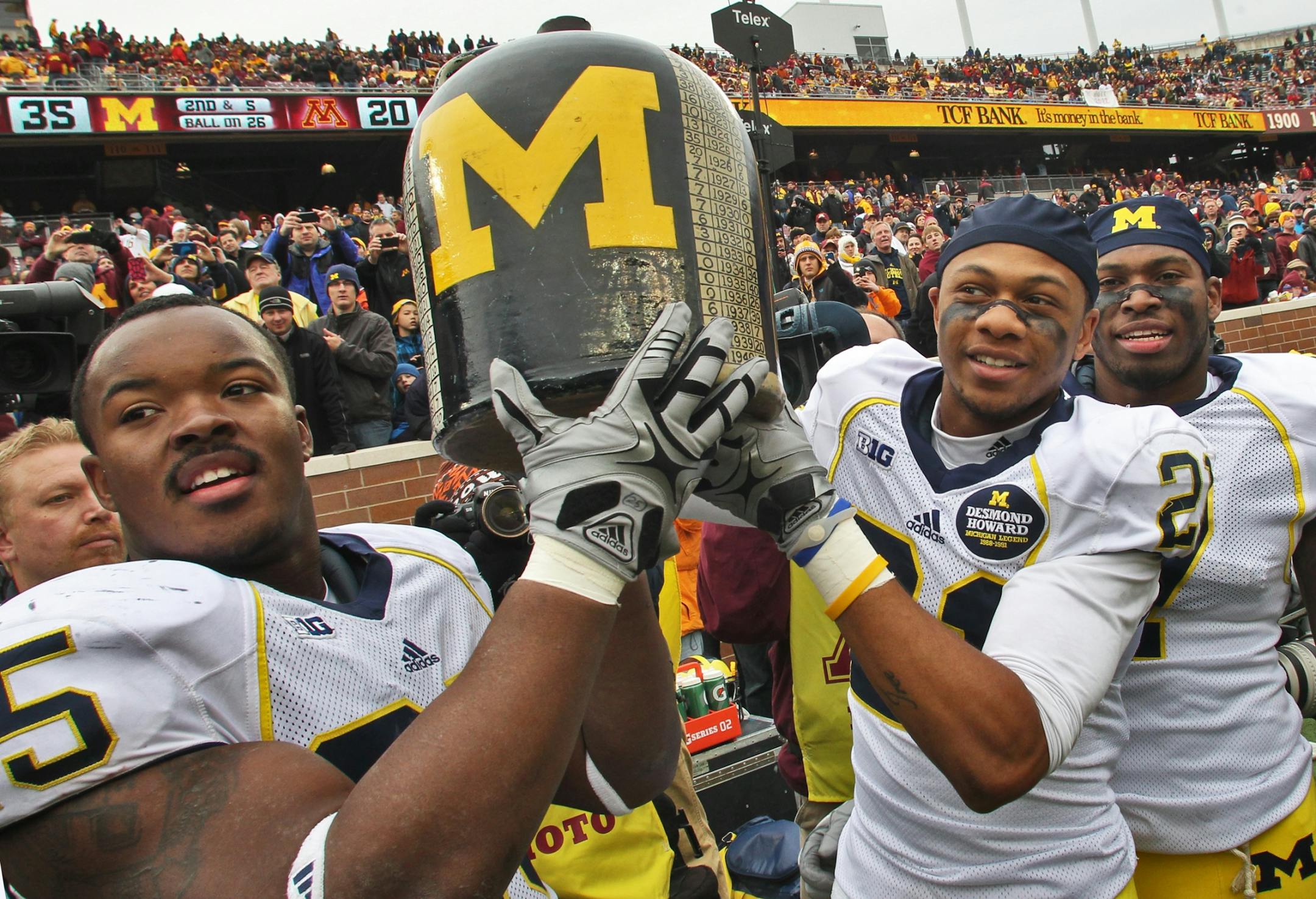 Michigan players hoist the Little Brown Jug.