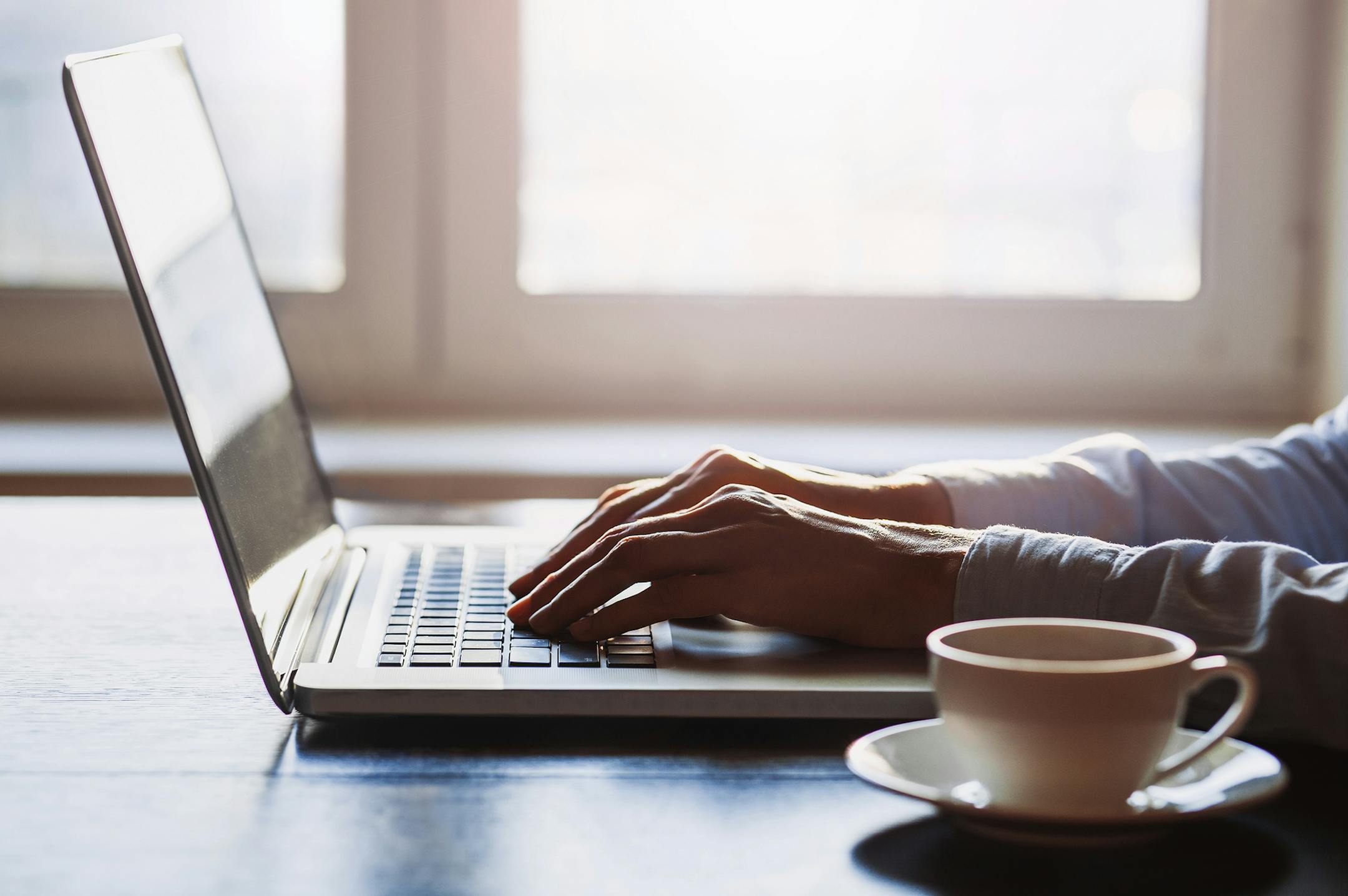 Close-up of human hands on laptop keyboard