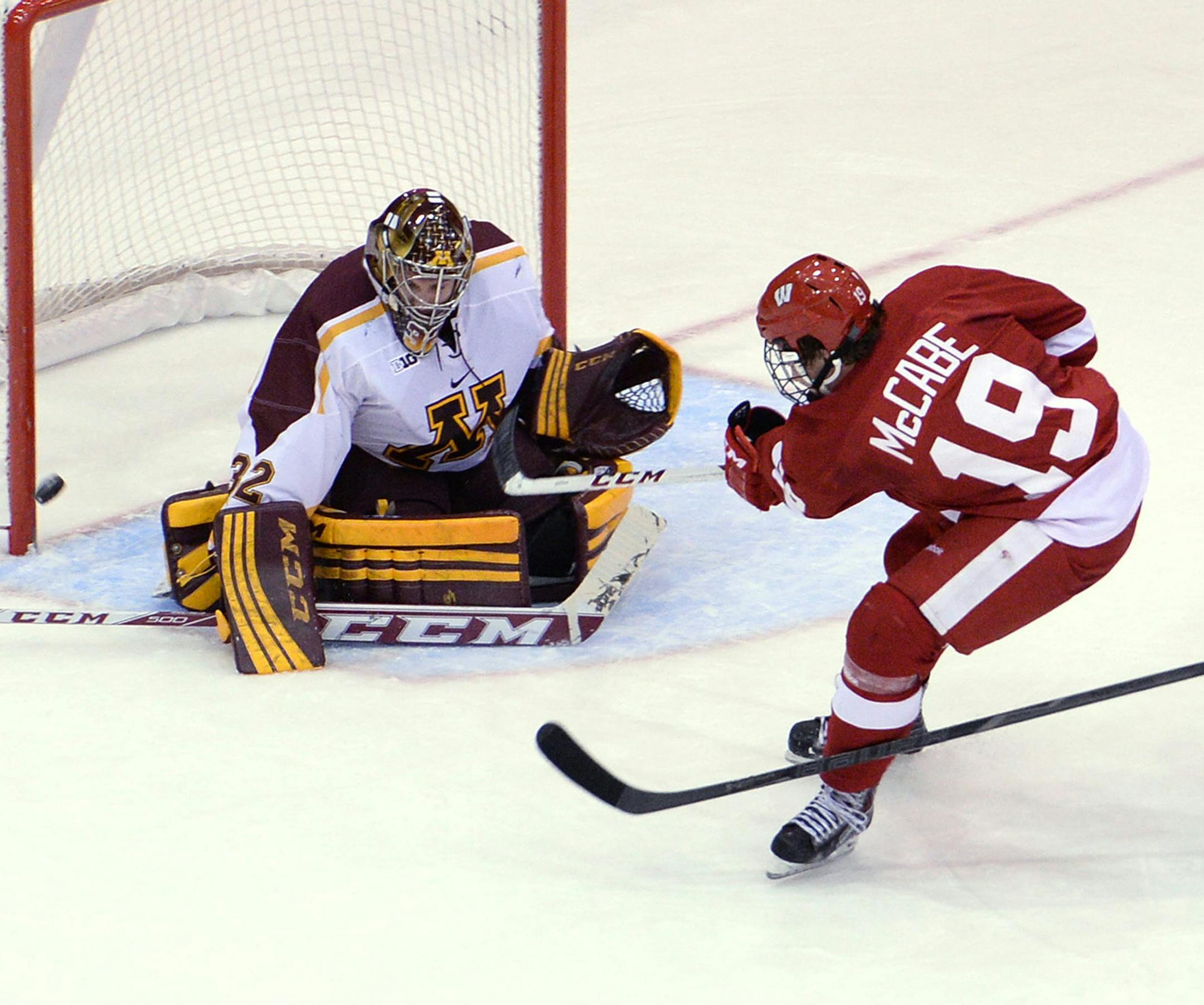 Wisconsin's Jake McCabe's shot is blocked by Minnesota's goaltender Adam Wilcox during the first period of a two-game home series for the Gophers at Mariucci Arena. ] (SPECIAL TO THE STAR TRIBUNE/BRE McGEE) **Jake McCabe (red, 19), Adam Wilcox (white, 32) ORG XMIT: MIN1311291823251662