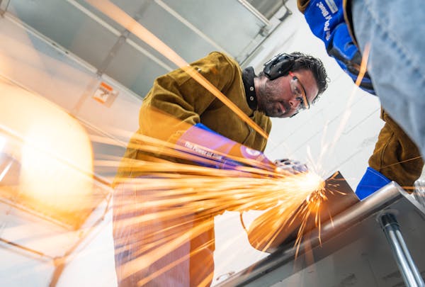 David Goldfeld, chief technology officer, and Phillip Schultz, a manufacturing engineer, left to right, work on grinding parts to make machinery that 