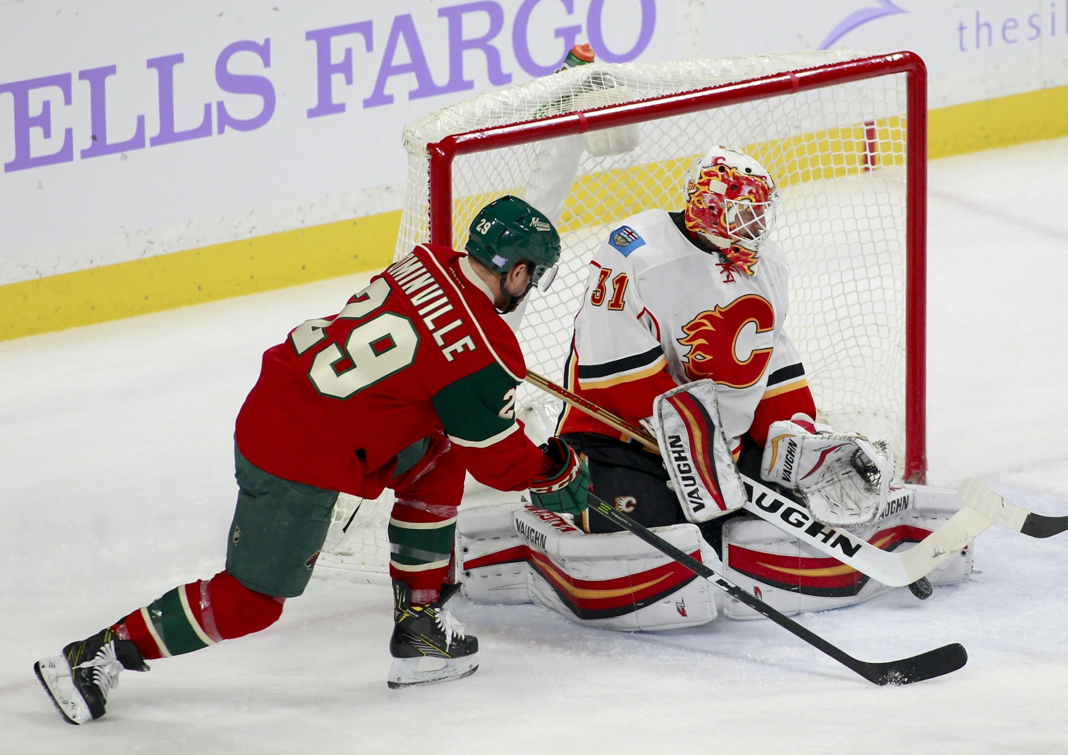 Minnesota Wild right wing Jason Pominville (29) looks for a rebound from Calgary Flames goalie Chad Johnson (31) during the first period of an NHL hockey game, Tuesday, Nov. 15, 2016, in St. Paul, Minn.