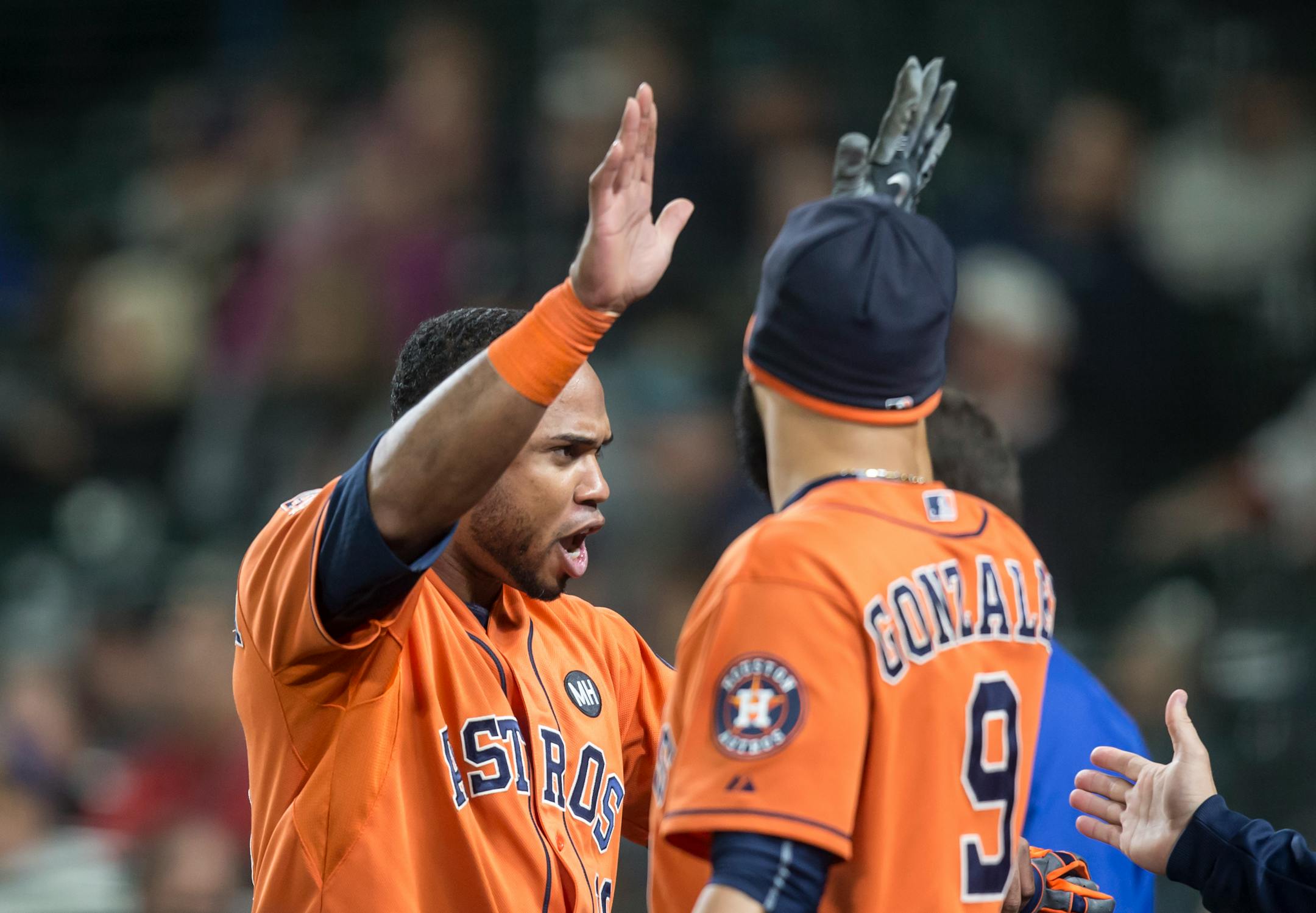 Houston Astros' Luis Valbuena, left, is congratulated by teammate Marwin Gonzalez after Valbuena scored on a three-run home run by Chris Carter during the sixth inning of a baseball game against the Seattle Mariners, Wednesday, Sept. 30, 2015, in Seattle. (AP Photo/Stephen Brashear)