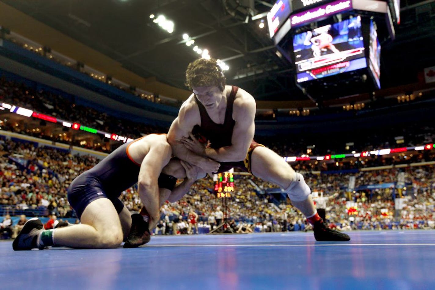 Virginia's Jonathan Fausey, left, and Minnesota's Kevin Steinhaus grapple during their 184-pound NCAA second-round match last spring.