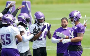 Vikings tight end Josh Oliver, right, is celebrated by his teammates after signing a contract extension with the team Tuesday before the first practic