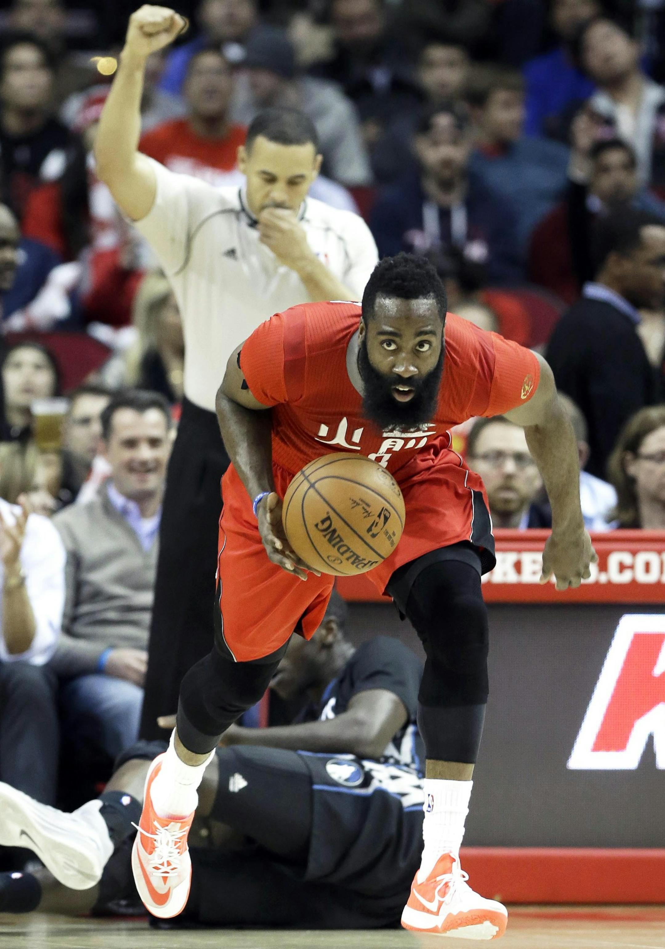 Houston Rockets' James Harden, right, heads up court against the Minnesota Timberwolves as referee Curtis Blair signals in the second half of an NBA basketball game Monday, Feb. 23, 2015, in Houston. Harden posted a triple double with 31 points, 11 rebounds and 10 assists. The Rockets won 113-102. (AP Photo/Pat Sullivan)