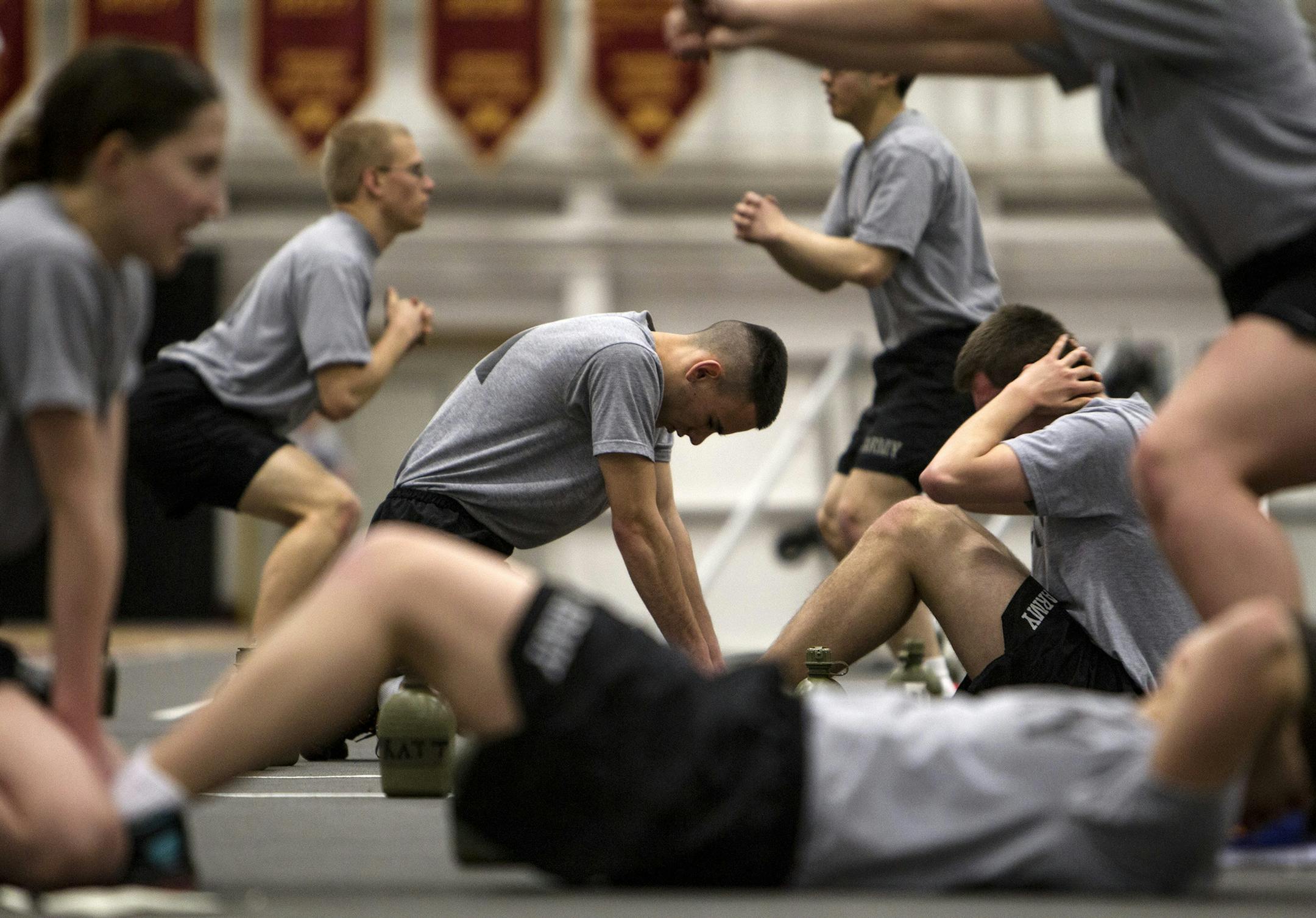 University of Minnesota Army ROTC Cadet Brennan Arendt, center, holds the feet of Cadet Colin Hazelton as the two switch off doing sit-ups during physical conditioning in the Fieldhouse on the Minneapolis campus March 3, 2014. (Courtney Perry/Special to the Star Tribune)
