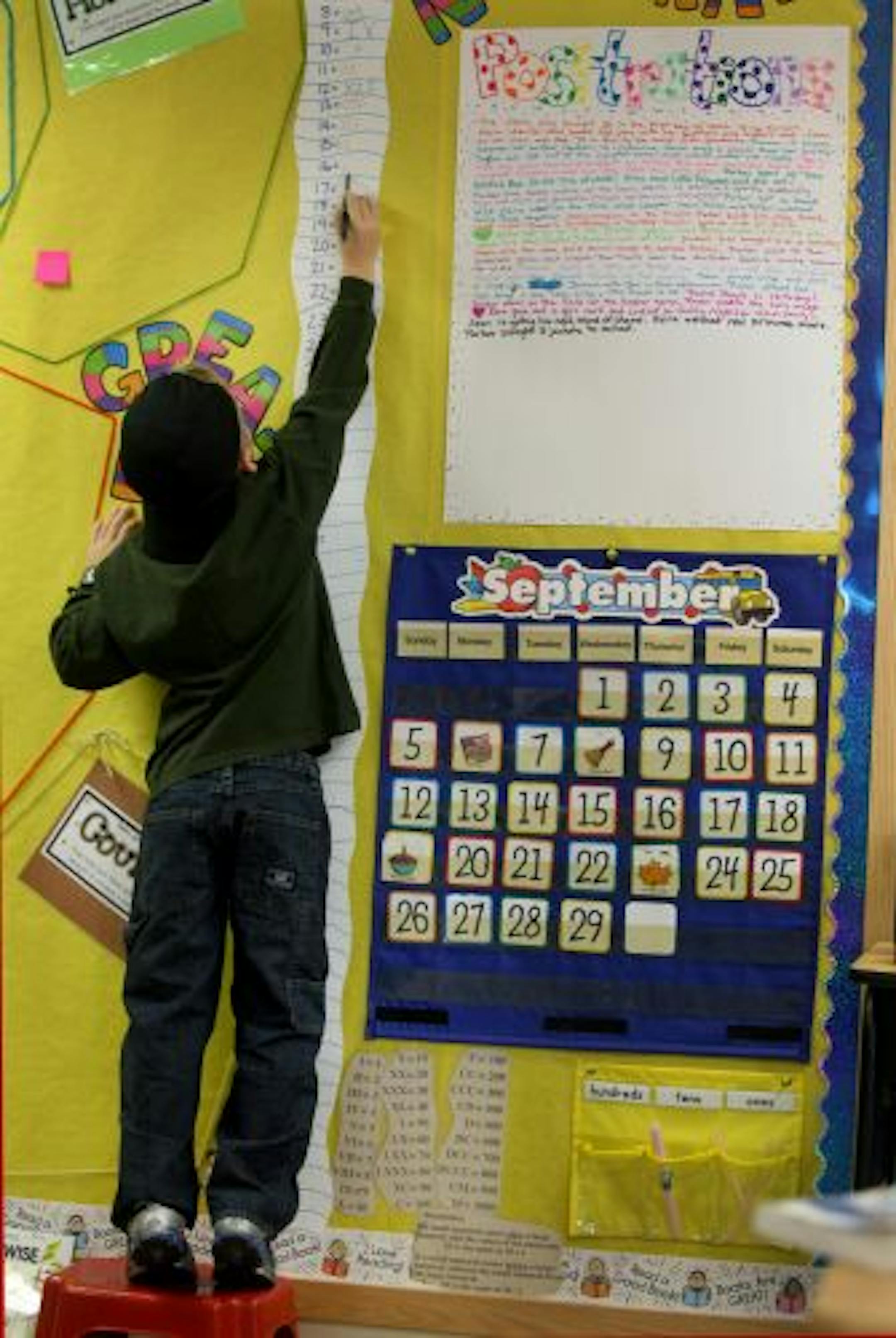 Parker Thornton, 6, got a little lift as he wrote Roman numerals as part of class.