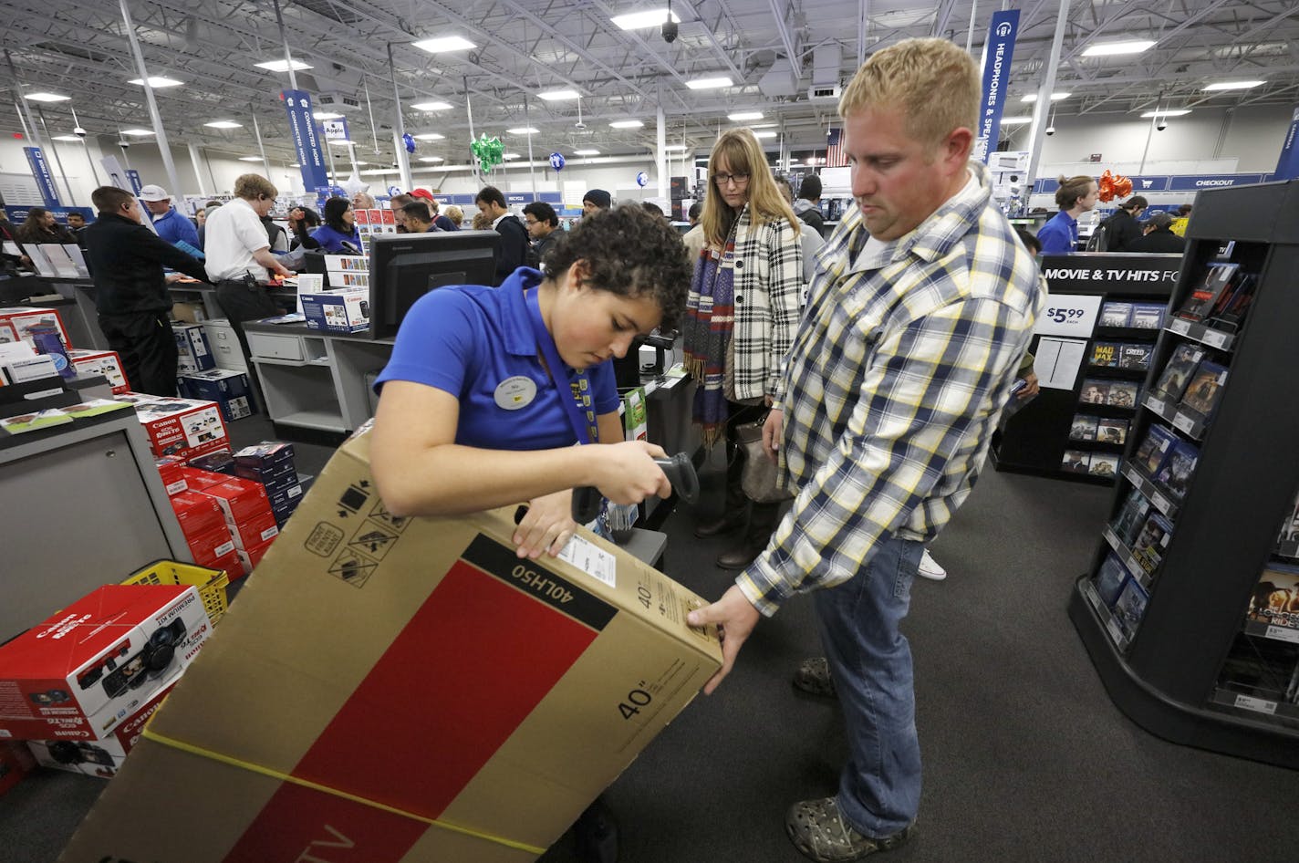 FILE -- Matt Schlenk and Clara Malikowski got help from Best Buy sales clerk Nia Colebrooke on their TV purchase on Thanksgiving Day in 2016.