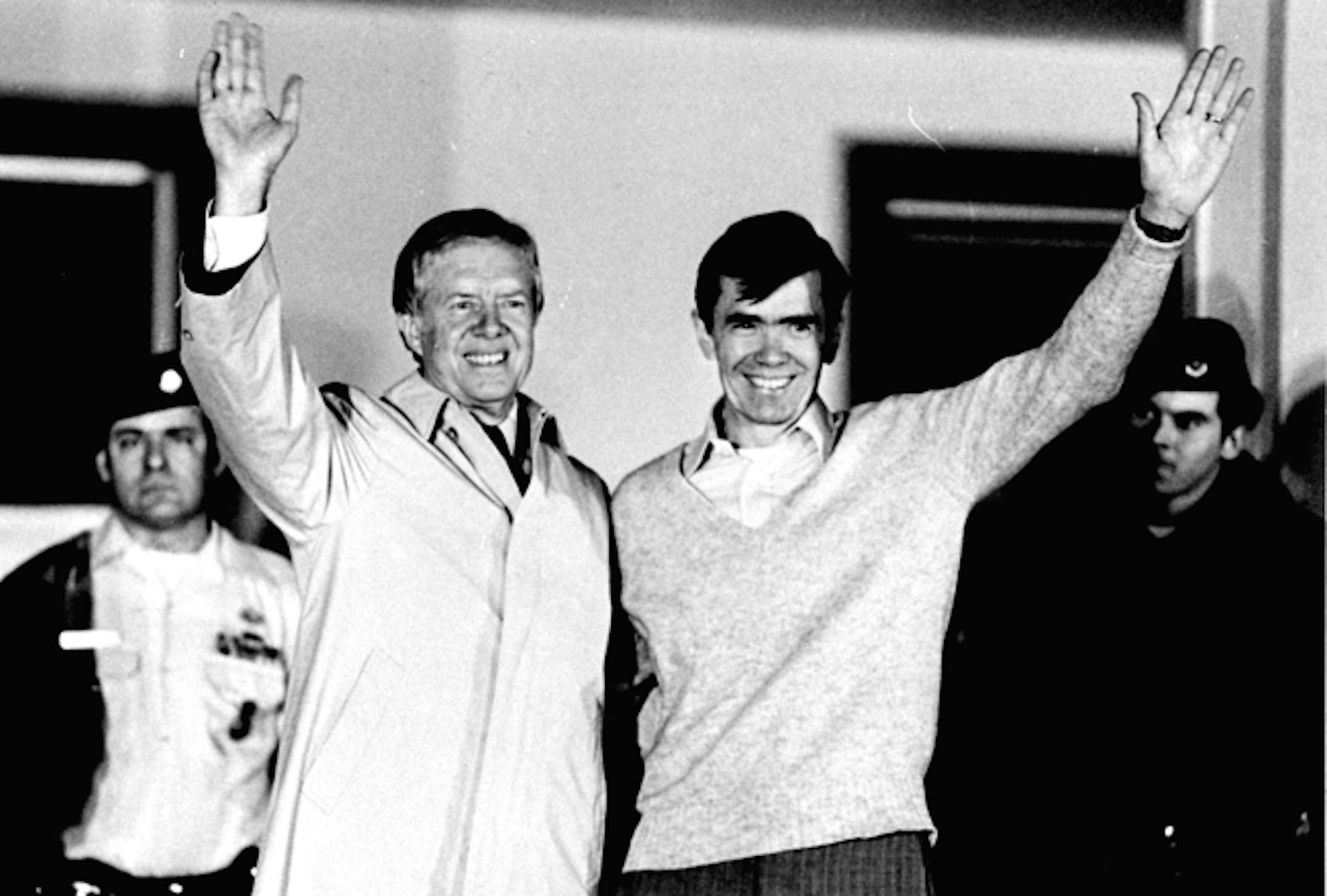 Former President Jimmy Carter waves as he looks at former hostage Bruce Laingen, from Bethesda, MD, former Charge d'Affaire at the U.S. Embassy in Tehran, on the balcony of the U.S. Air Force hospital, January 22, 1981 in Wiesbaden, Germany. Carter paid a three hour visit to the hostages from Iran at the hospital, where they are lodged after 444 days of captivity.