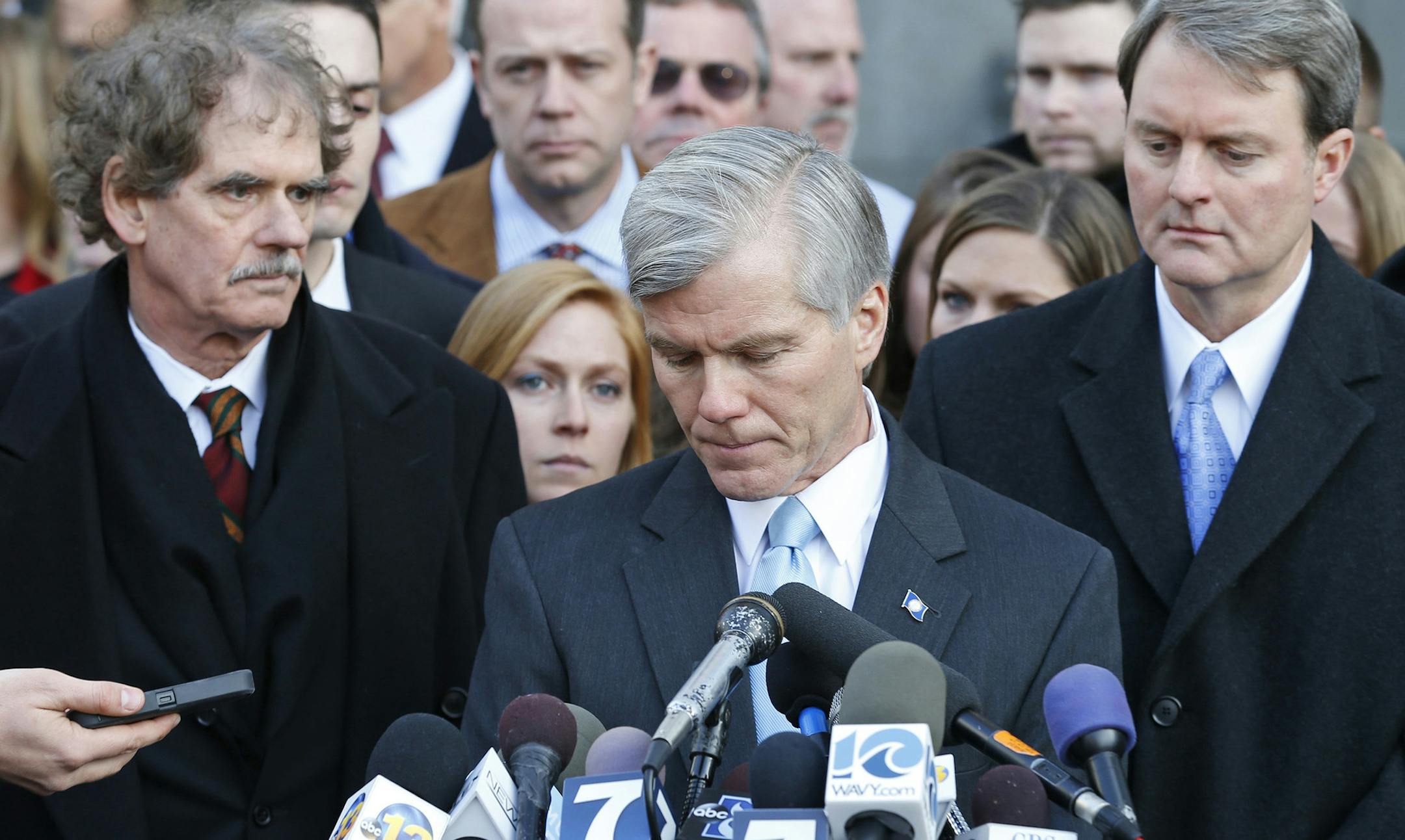 Former Virginia Gov. Bob McDonnell, center, composes himself as he addresses the media outside federal court in Richmond, Va., Tuesday, Jan. 6, 2015. McDonnell was sentenced to two years prison and two years probation in his corruption case. His attorney's Henry Asbill, left and John Brownlee, right, look on. McDonnell is to report to prison by Feb. 9. His wife, who was convicted on eight counts of corruption, will be sentenced Feb. 20. (AP Photo/Steve Helber) ORG XMIT: RIC110